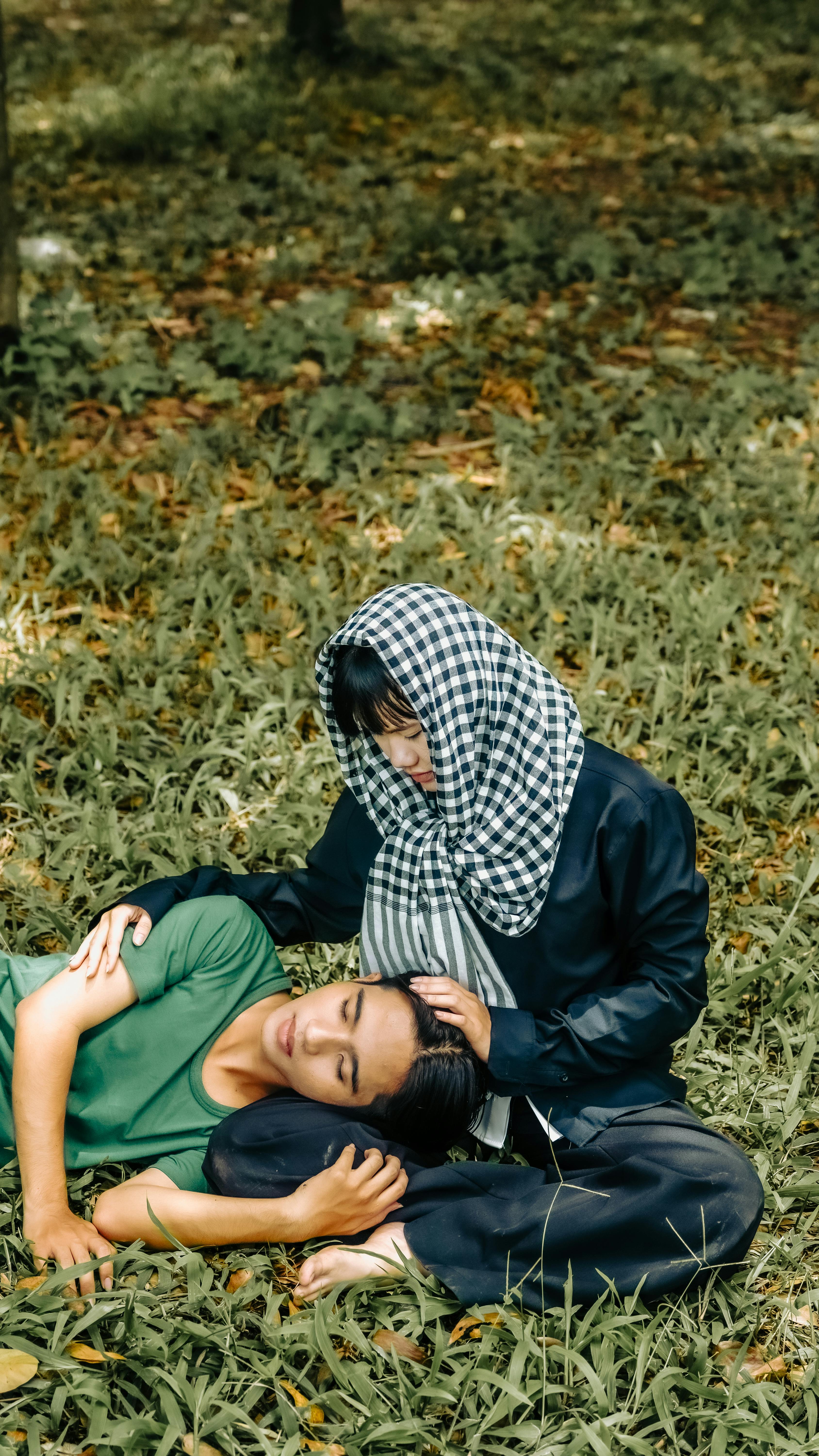 Two People Resting on Park Grass