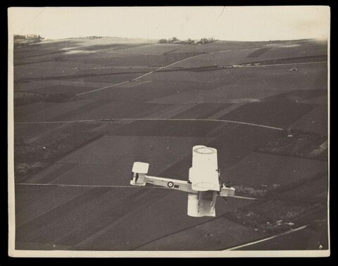 Vintage Military Biplane Over Farmland