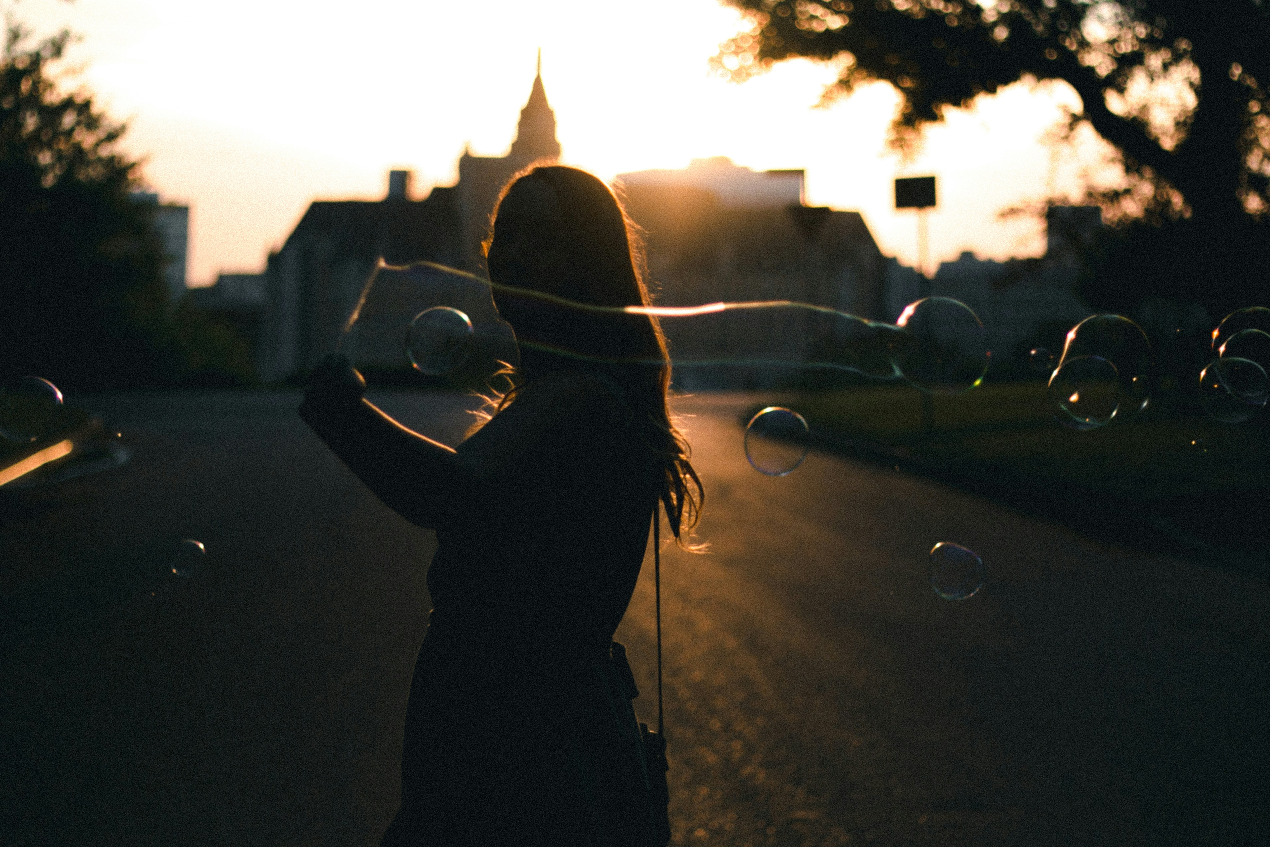 Woman Blowing Bubbles at Sunset