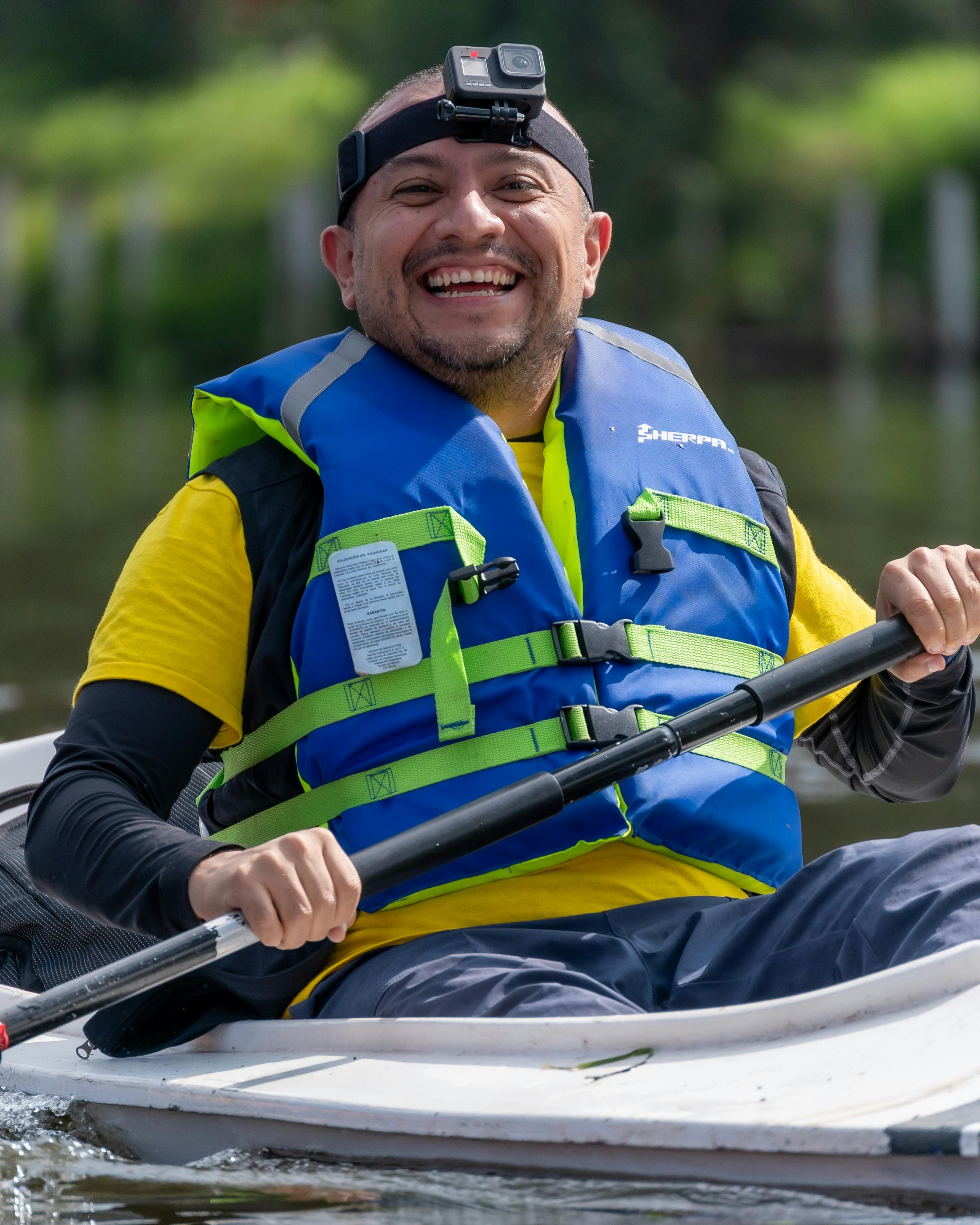Smiling Man Kayaking on Calm River