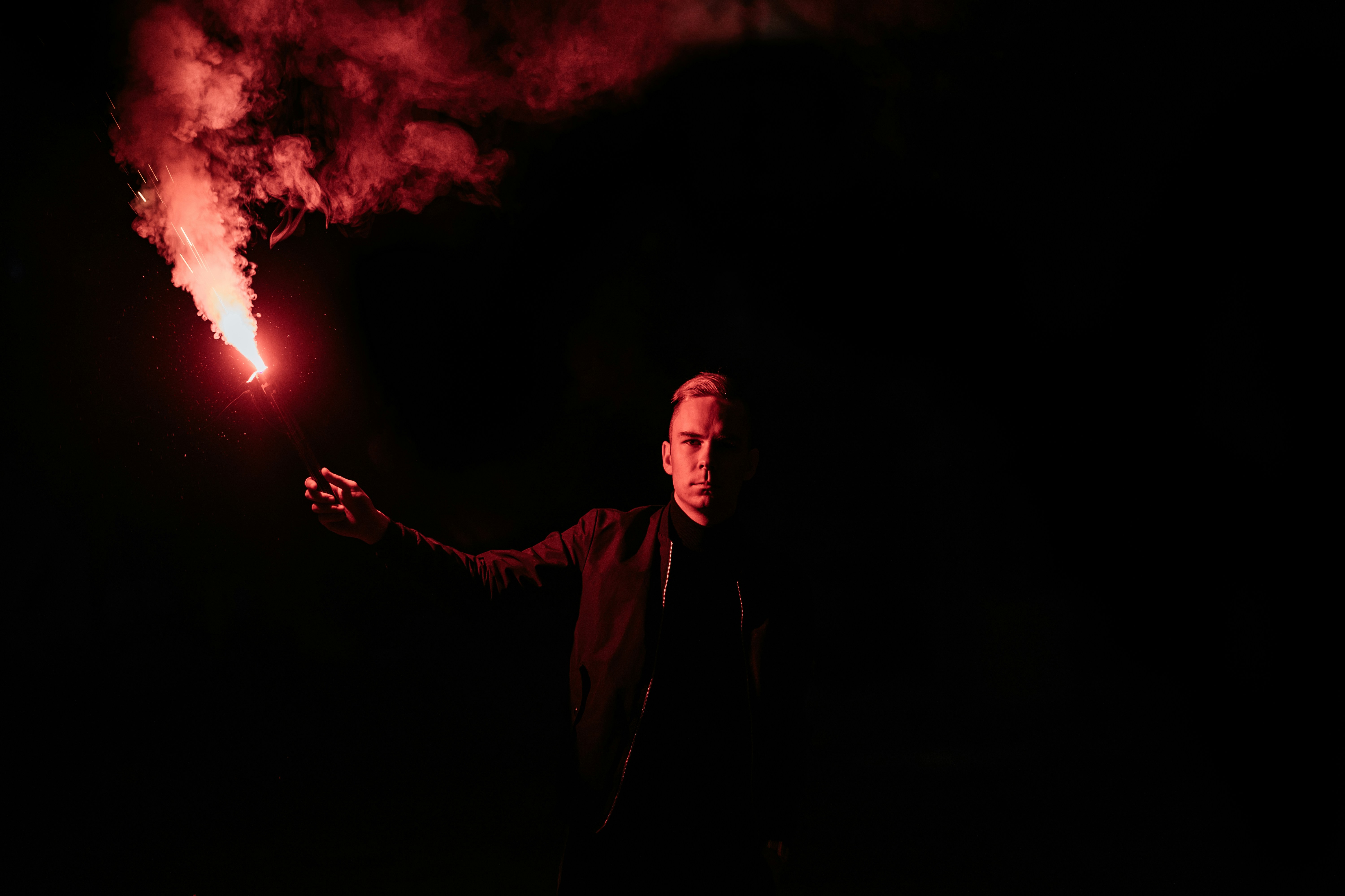 Man Holding Red Flare In Dark