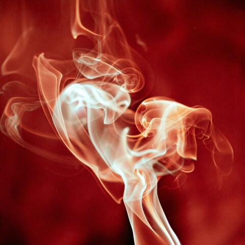 Wispy Smoke Against Red Background