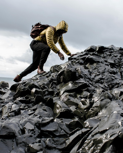 Hiker Climbing Dark Wet Rocks