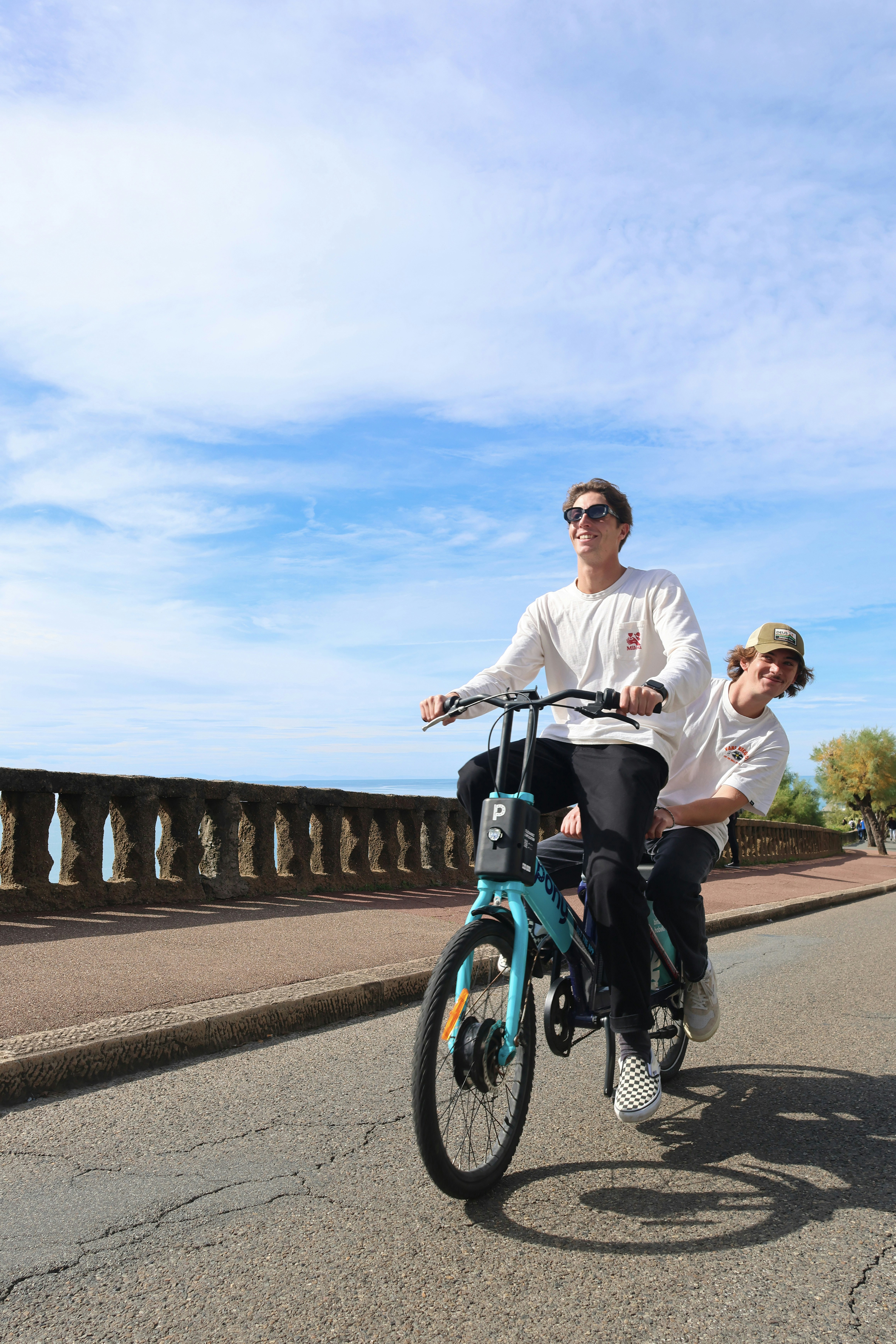Two Men Riding E-Bike By Coastal Road