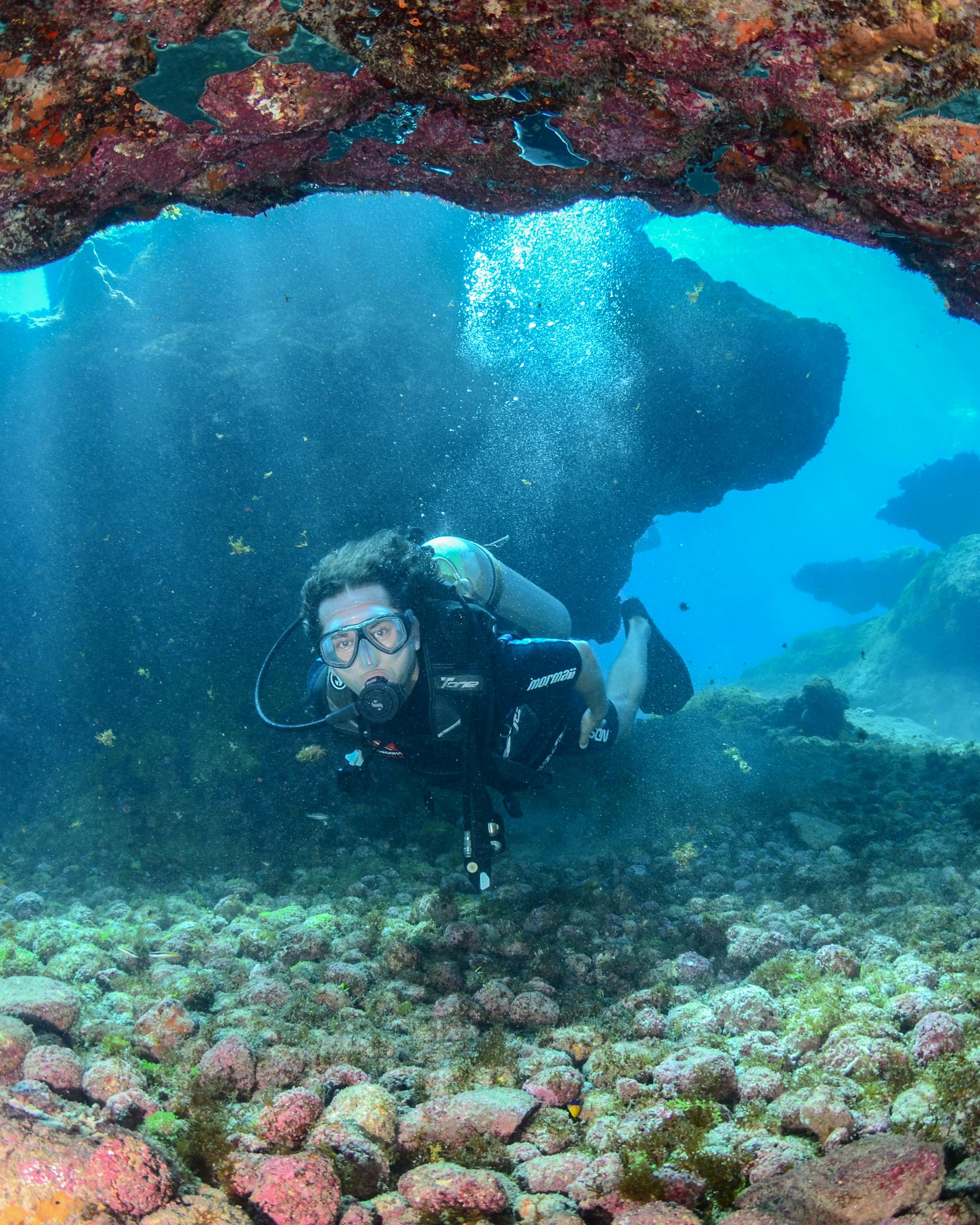 Scuba Diver Under Underwater Rock Arch
