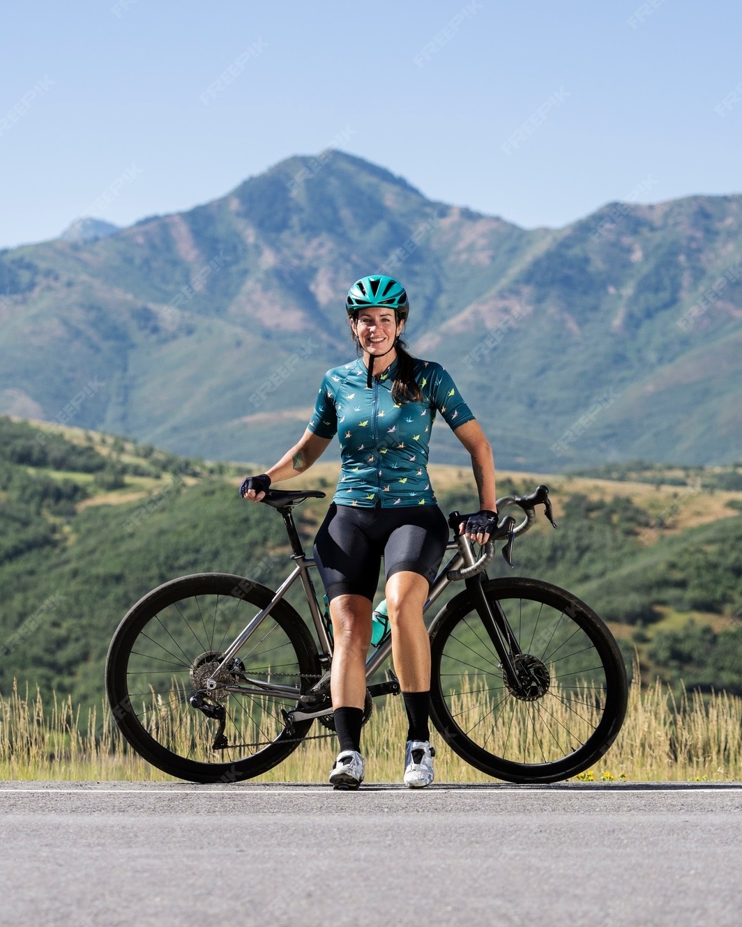 Female Cyclist Posing With Bike In Mountains