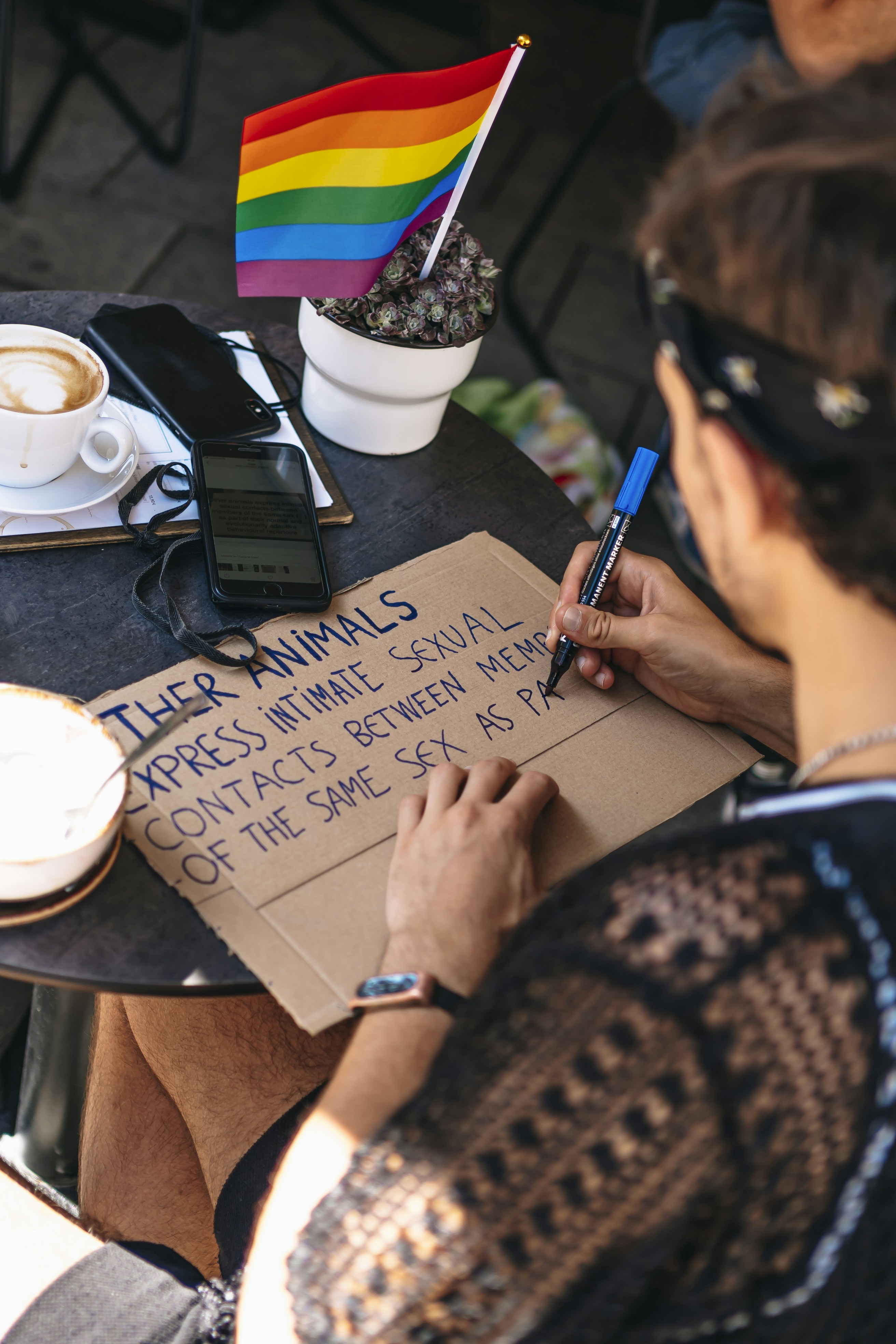 Making Pride Protest Sign at Outdoor Cafe