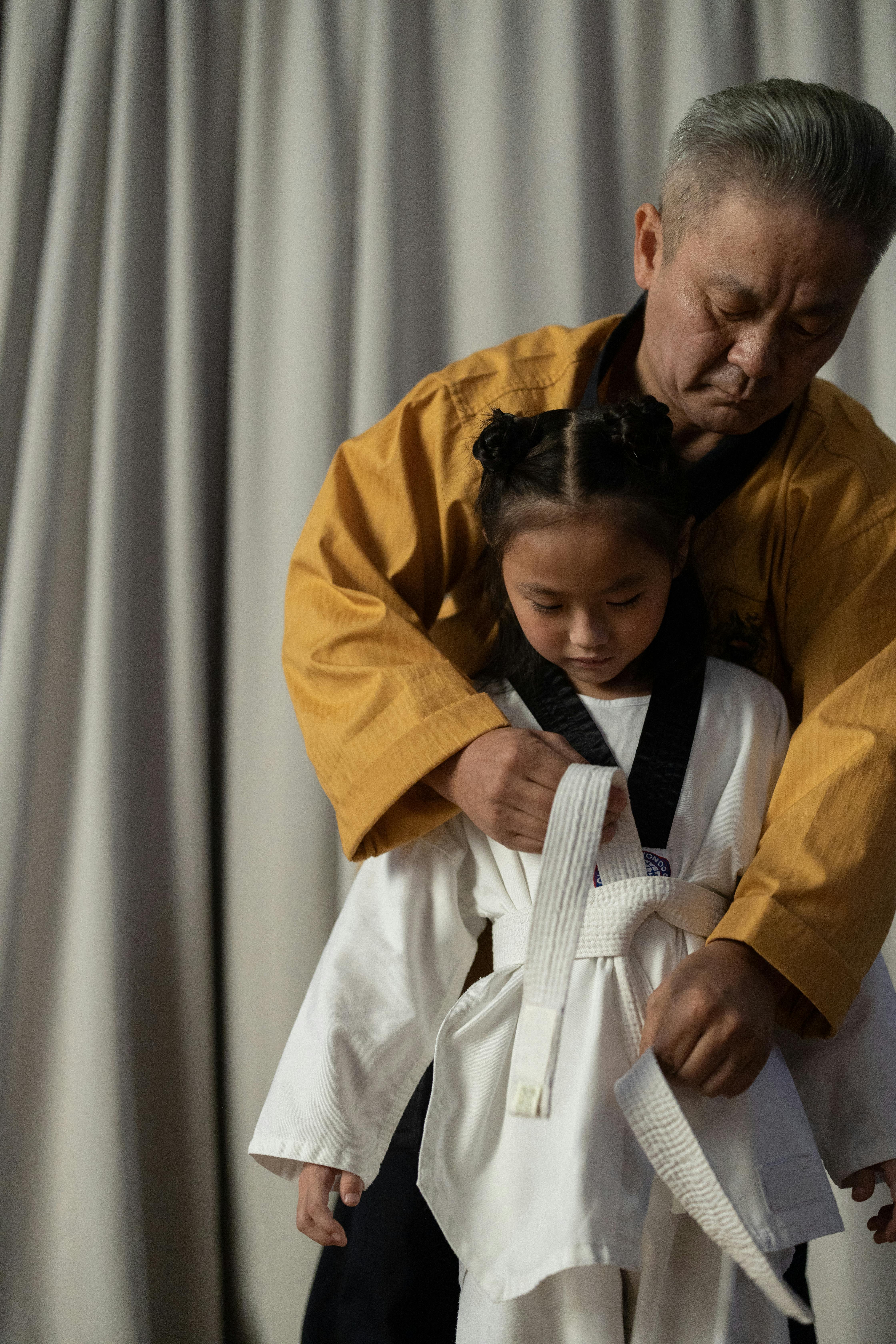 Master Tying Girl's Taekwondo Belt