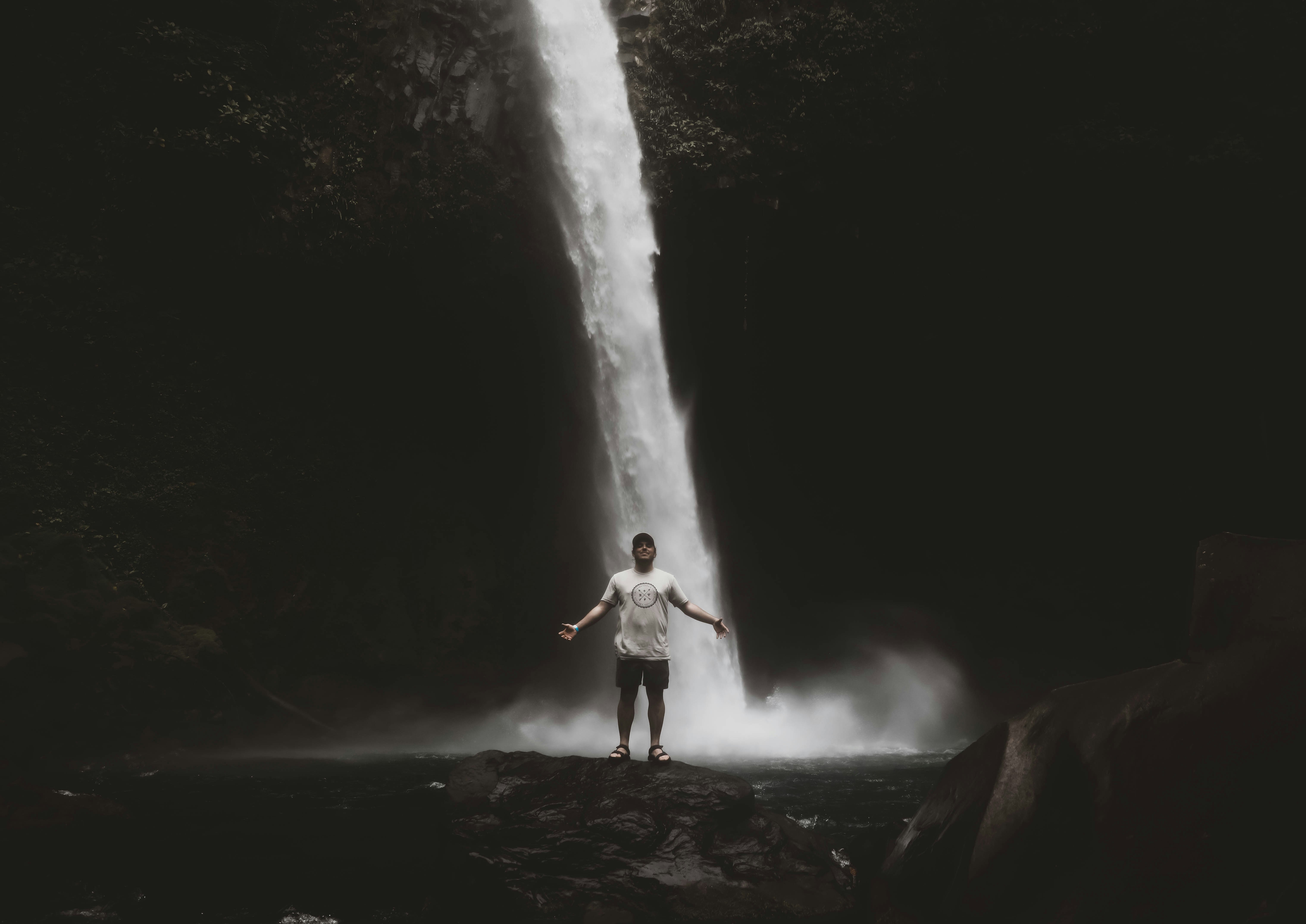 Man Standing Before Waterfall