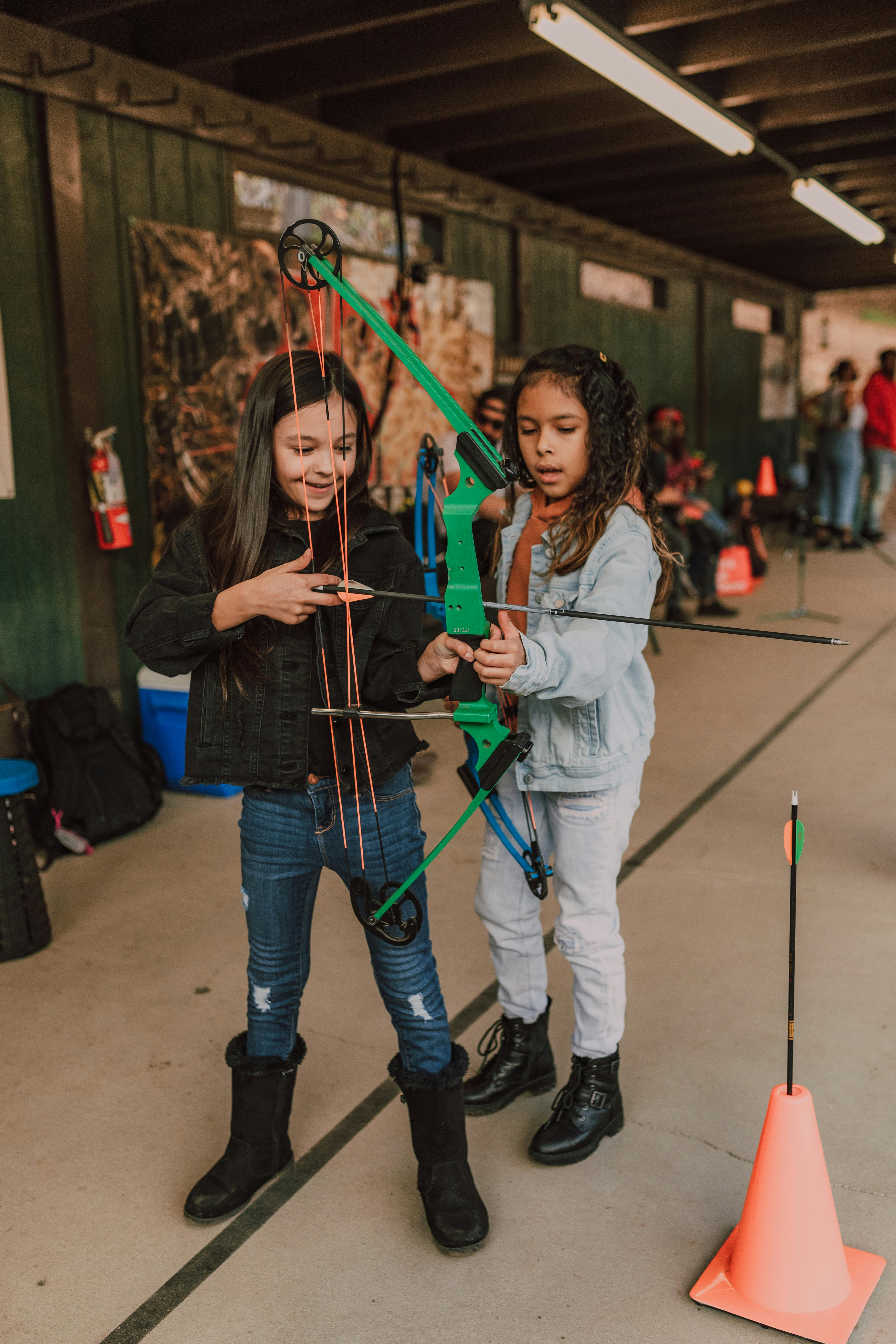 Two Girls At Indoor Archery Range