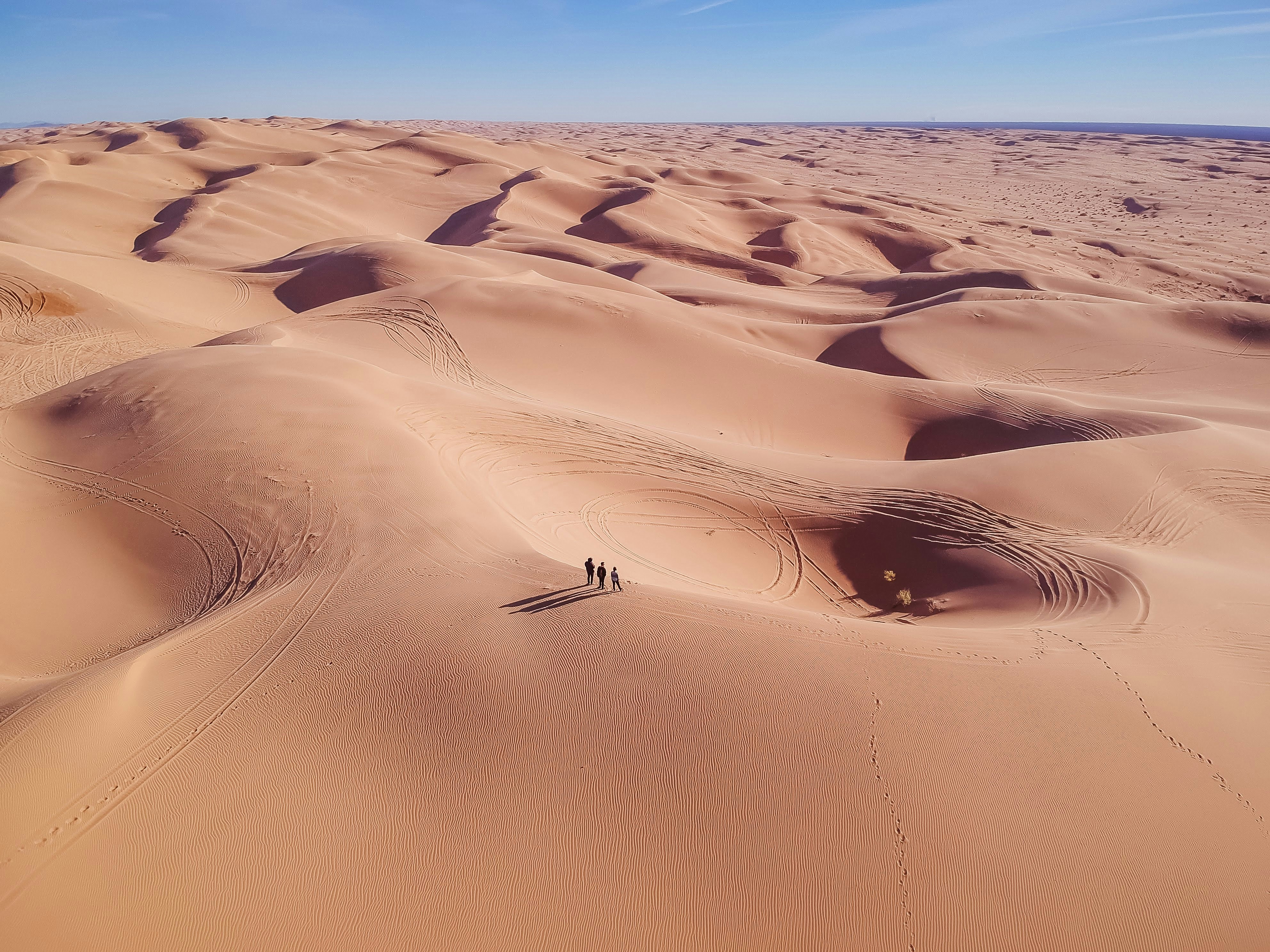 Three Hikers on Desert Sand Dunes