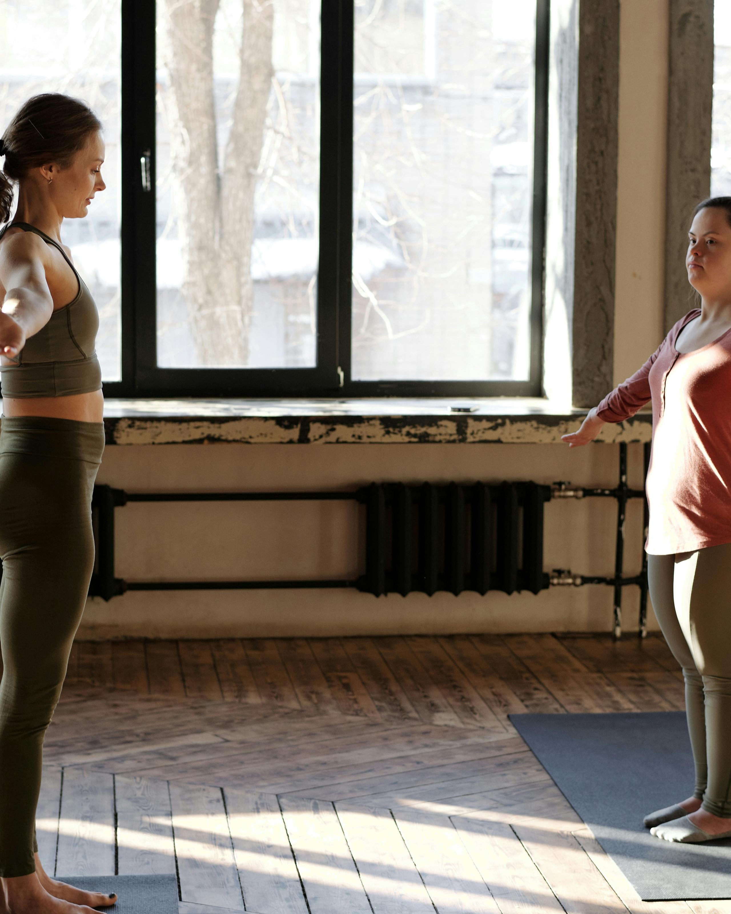 Two Women Practicing Yoga Indoors