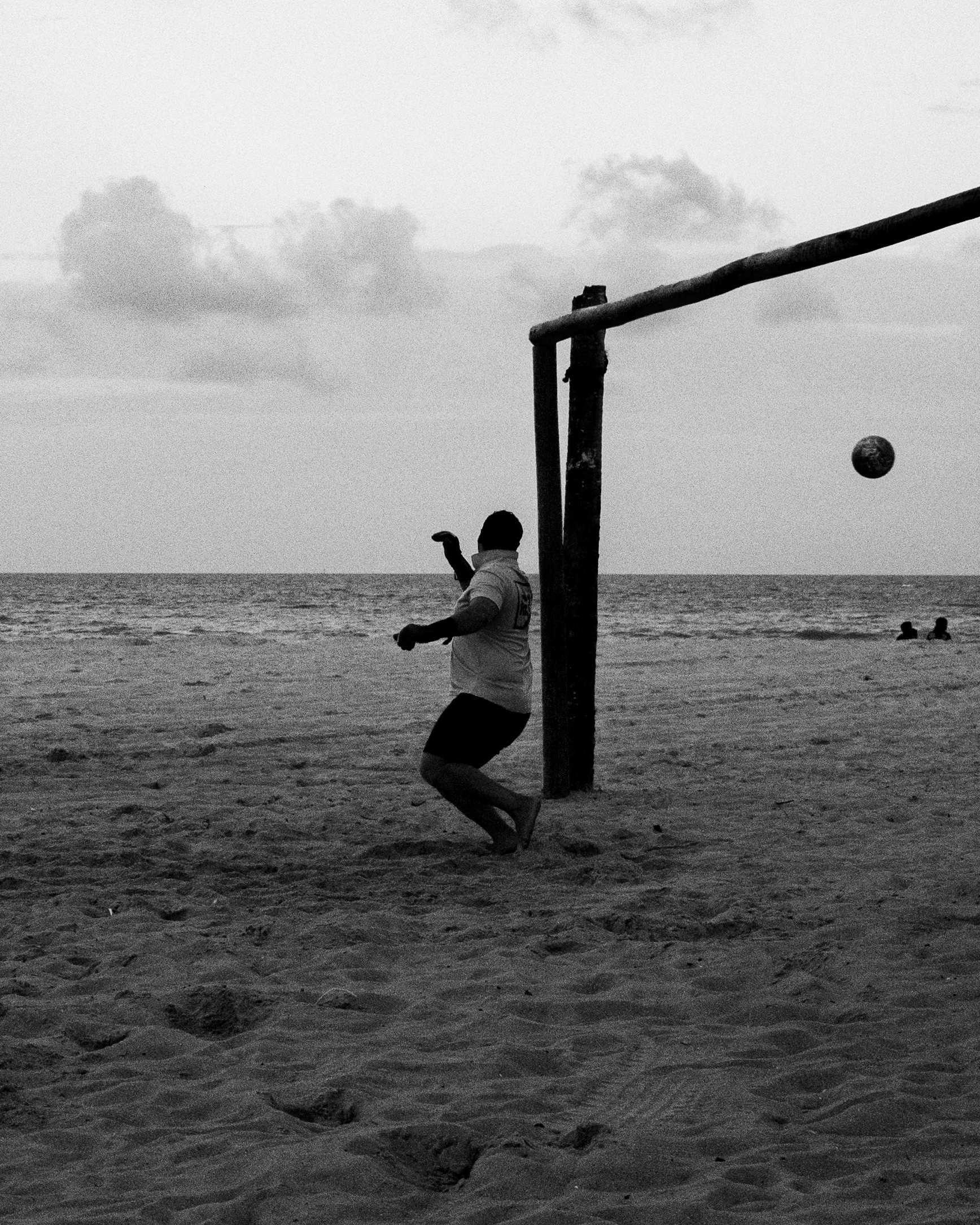 Man Playing Soccer on Beach