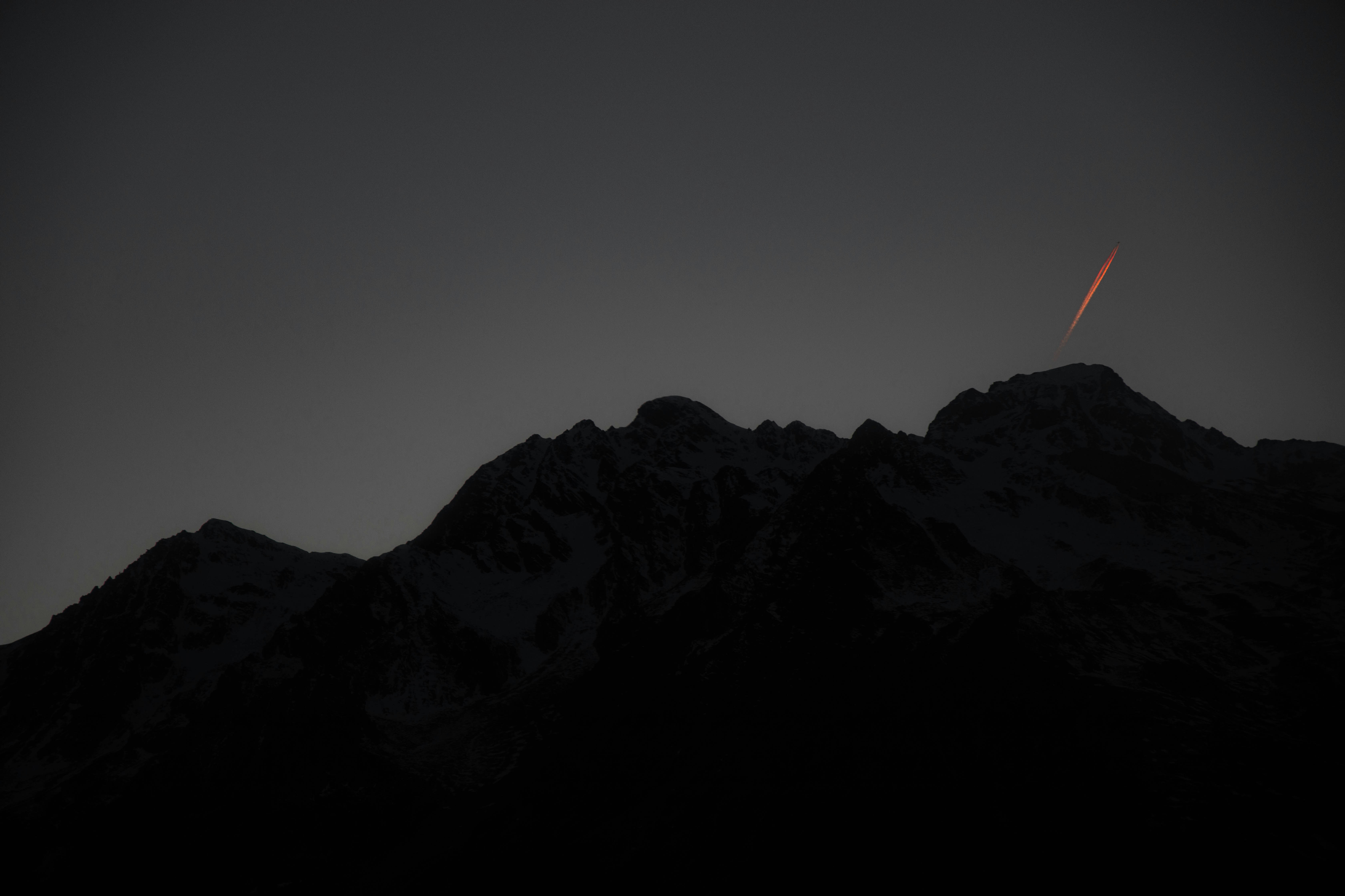 Dusk Mountain Silhouette with Contrail