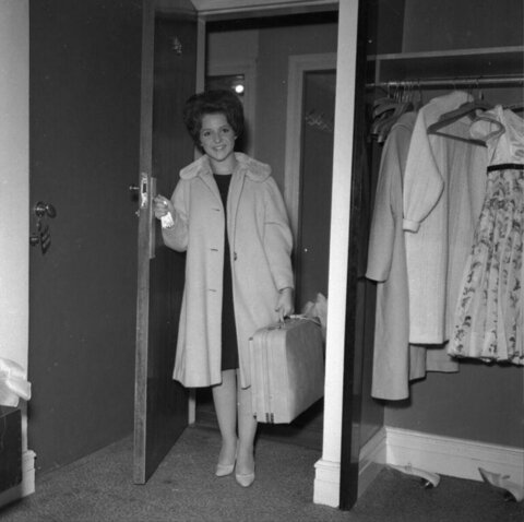 Woman Carrying Suitcase Entering Room