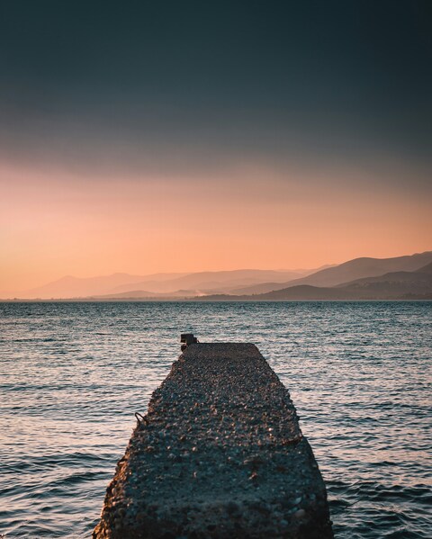Stone Pier on Sea at Sunset