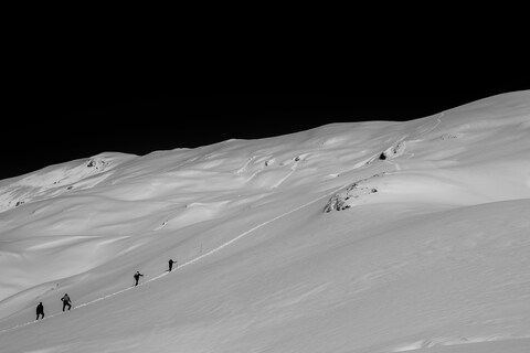 Four Climbers Ascending Snowy Mountain
