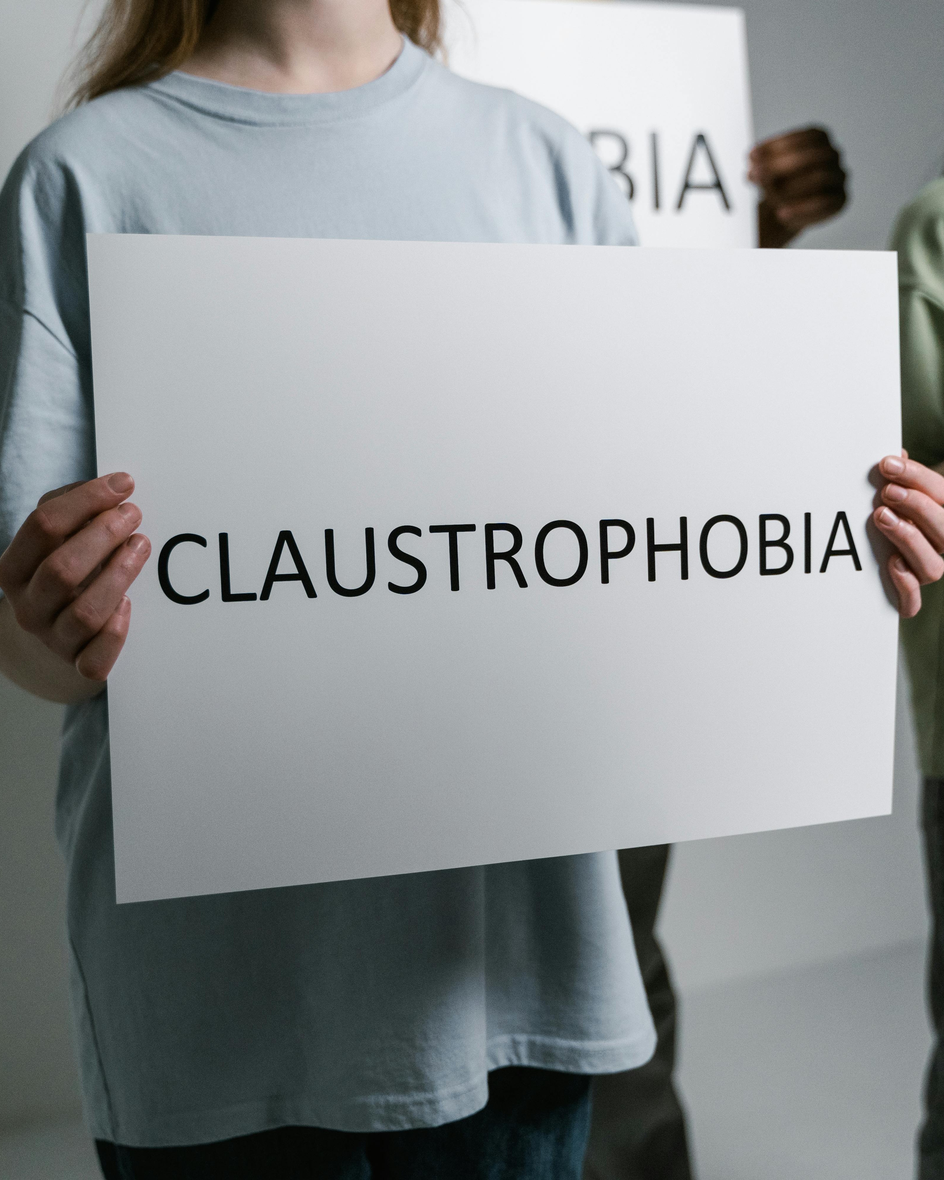 Person Holding Claustrophobia Sign