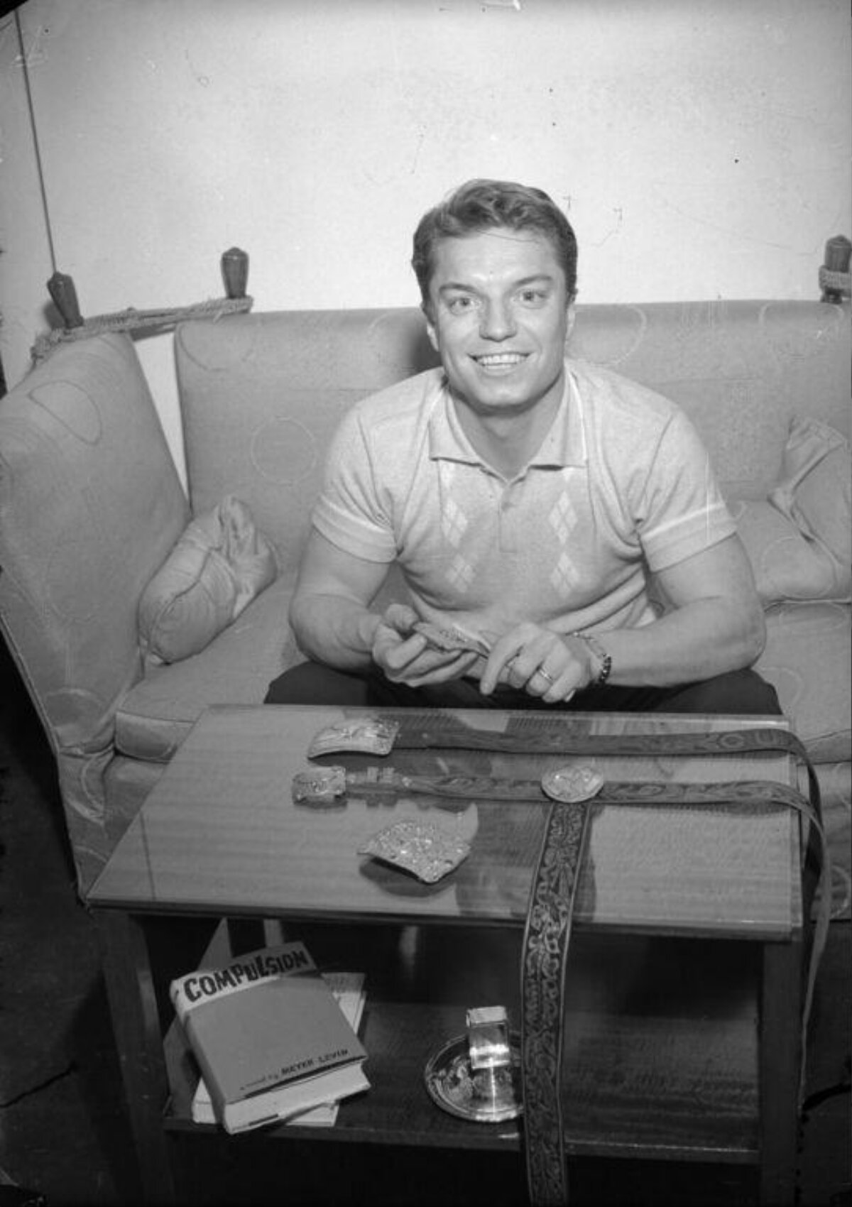 Smiling Man Displaying Decorative Belts