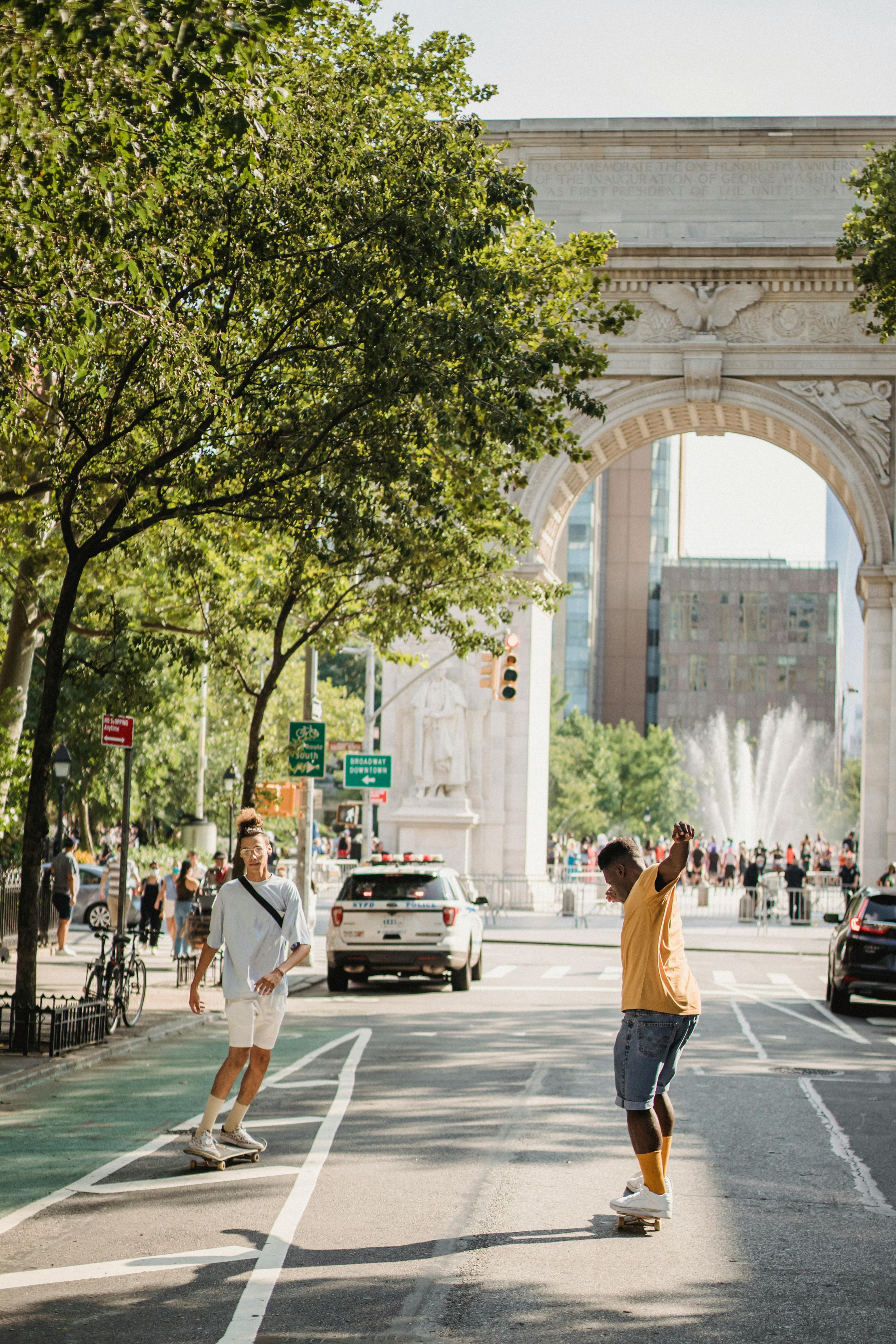 Two Skateboarders at Washington Square Arch