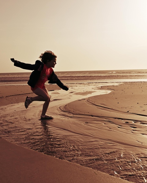 Child Running on Beach Shore