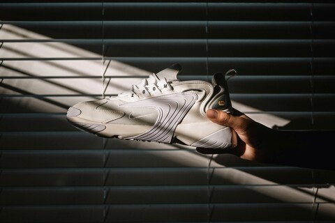 White Nike Zoom Sneaker Held by Hand