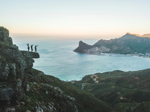 Three Hikers on Coastal Cliff Overlook