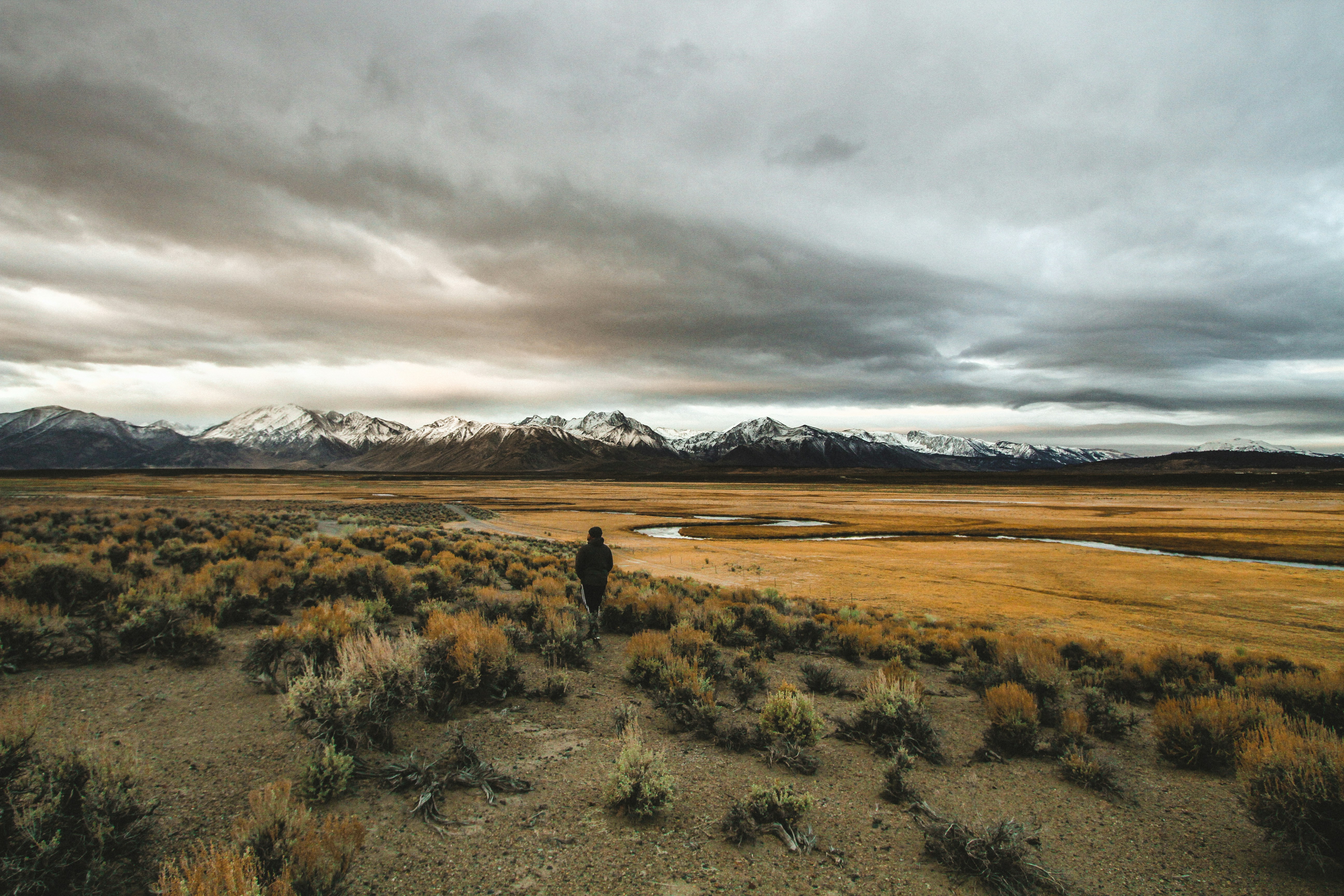 Lone Walker Facing Distant Snow Mountains