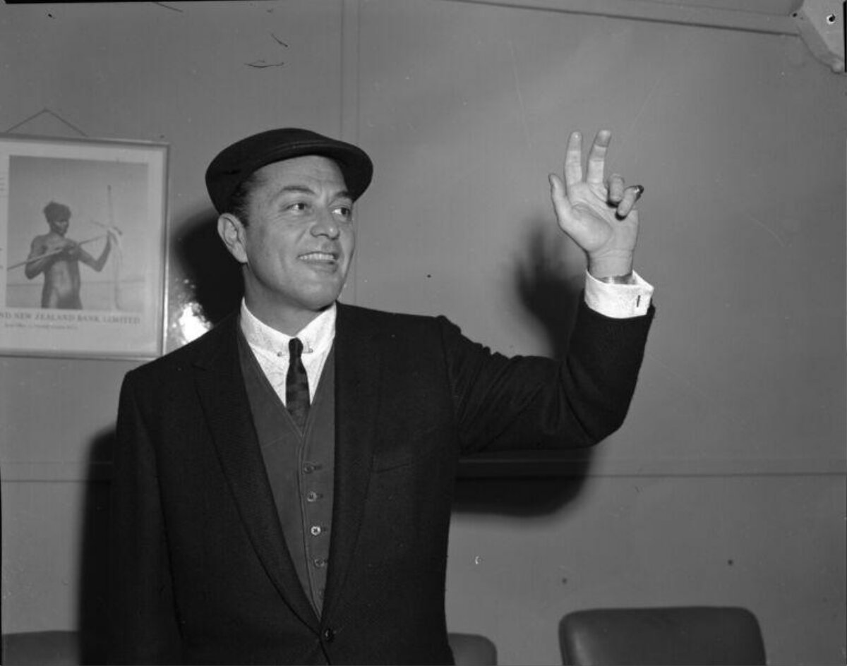 Smiling Man Raising Hand in Indoor Portrait