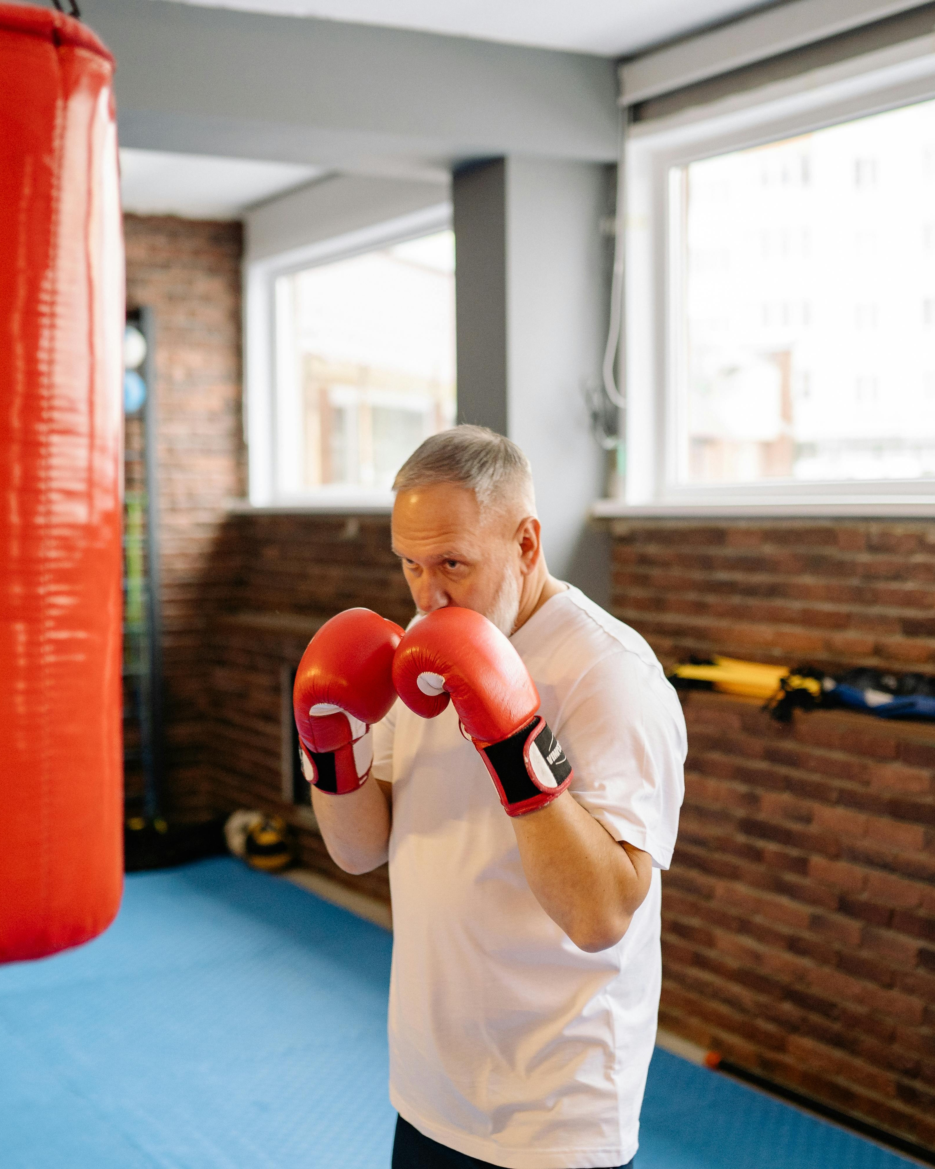 Older Man Boxing Training In Gym