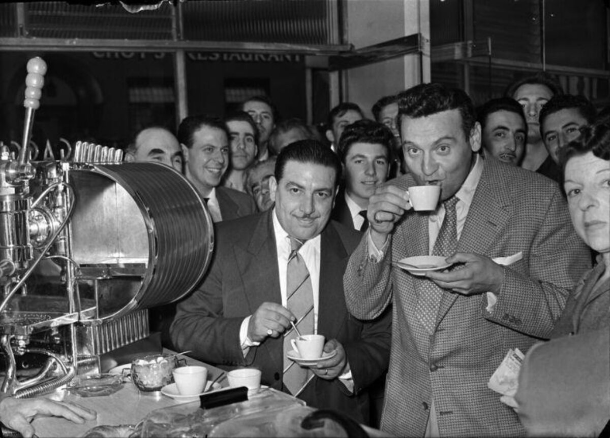 Men Tasting Coffee Next to Vintage Espresso Machine