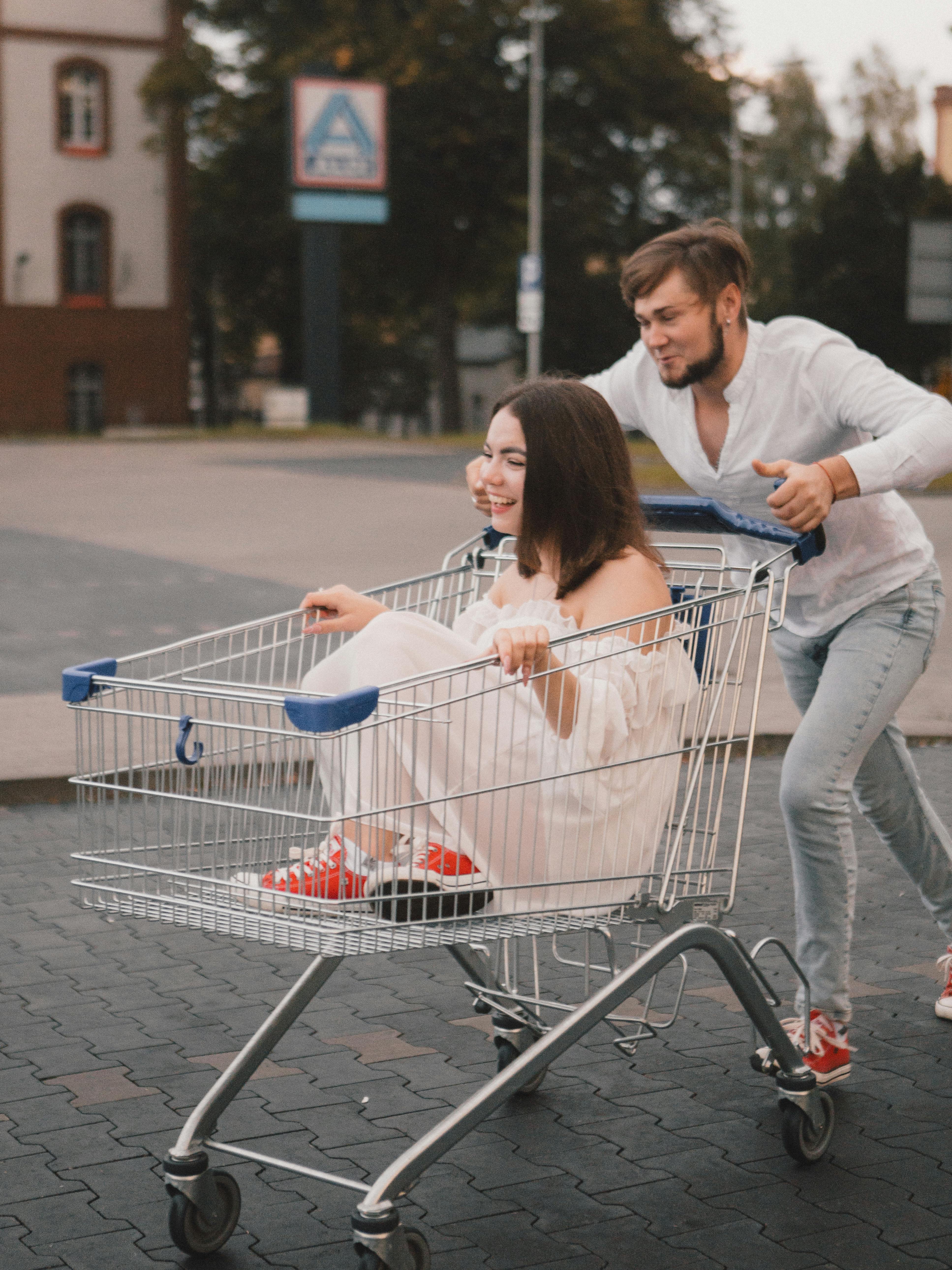 Man Pushing Woman in Shopping Cart