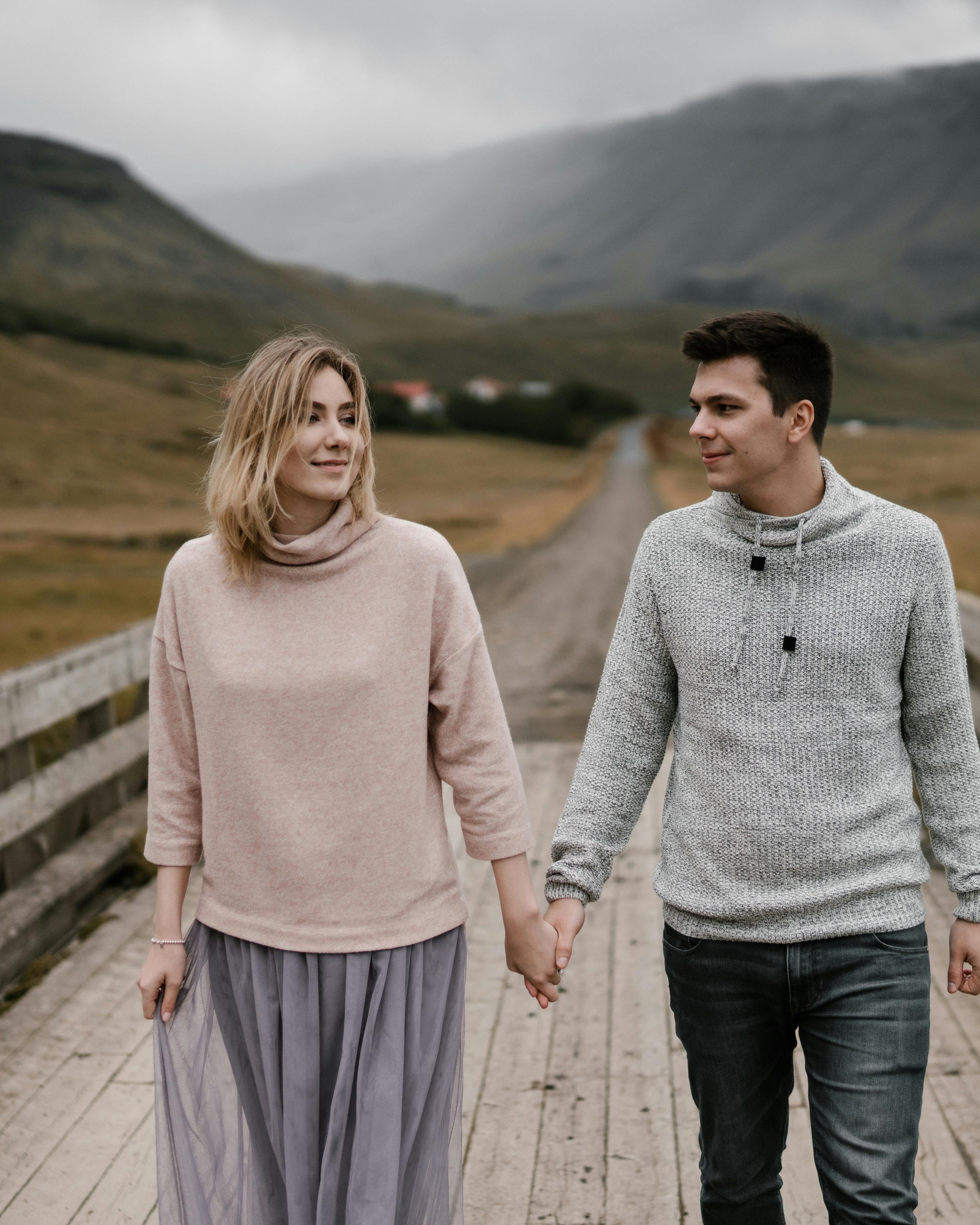 Couple Holding Hands on Country Bridge