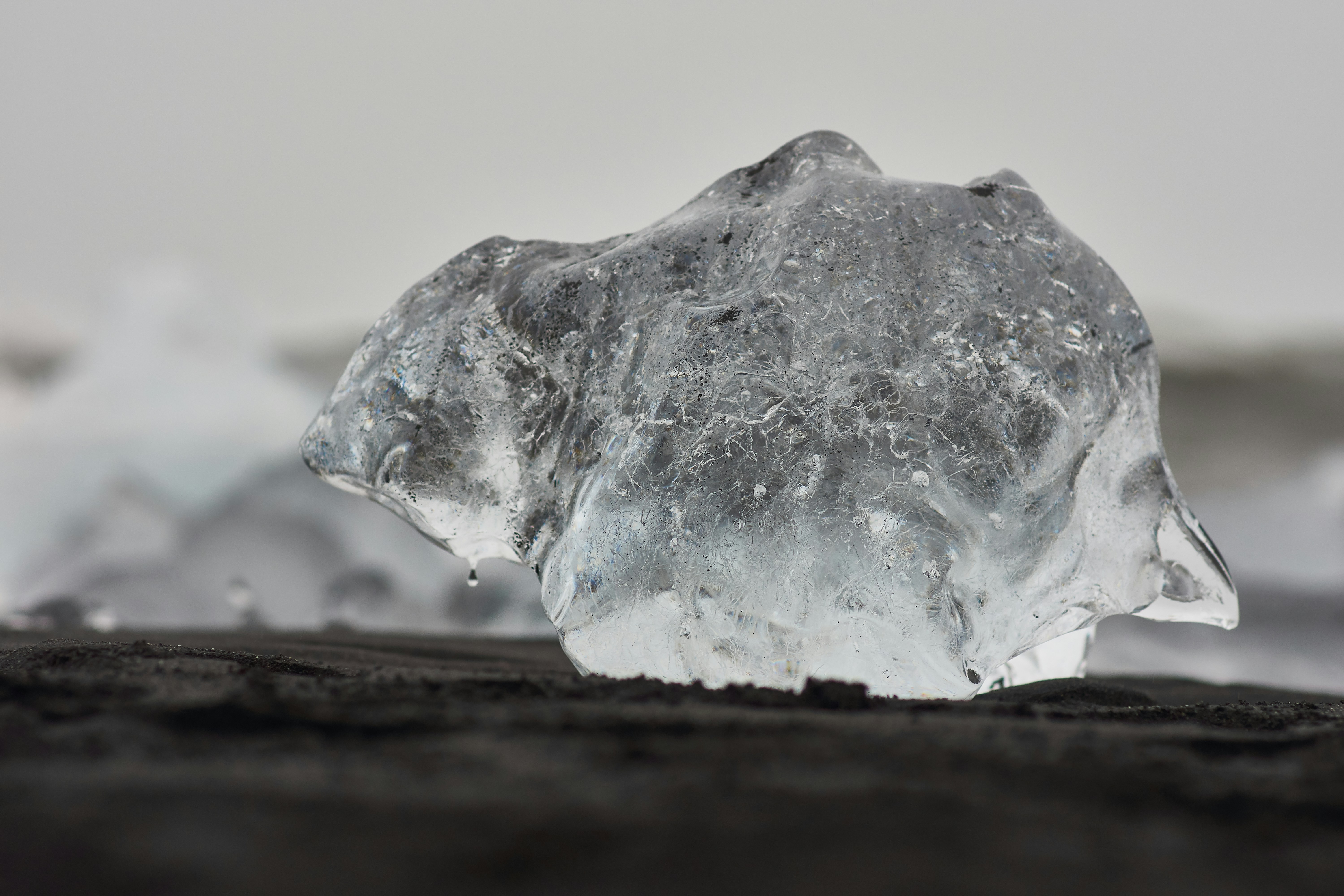 Transparent Ice Chunk on Black Sand