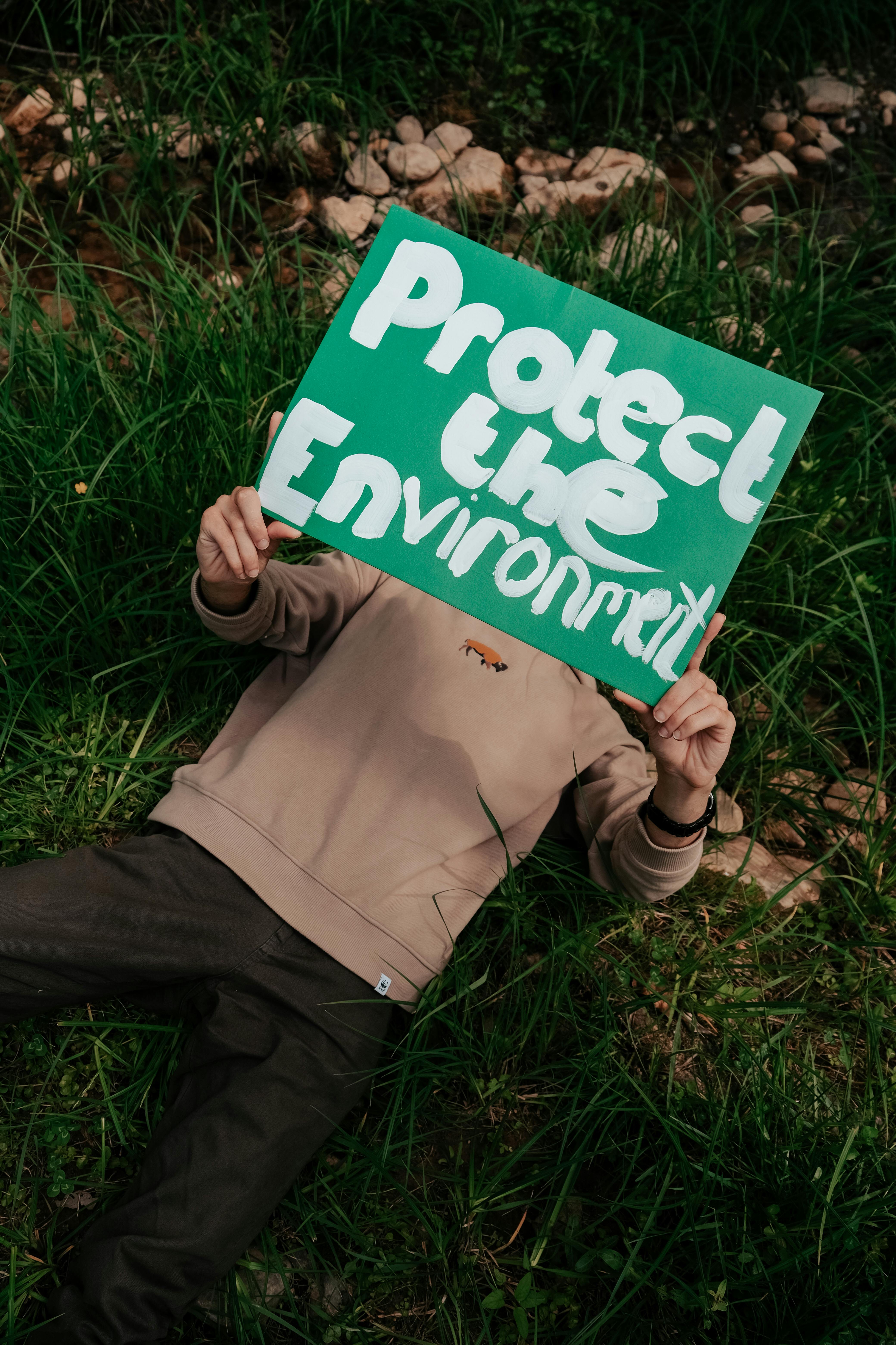Person Holding Protect the Environment Sign