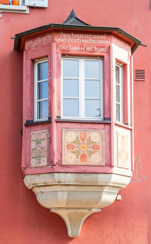 Decorated Oriel Window on Red Facade