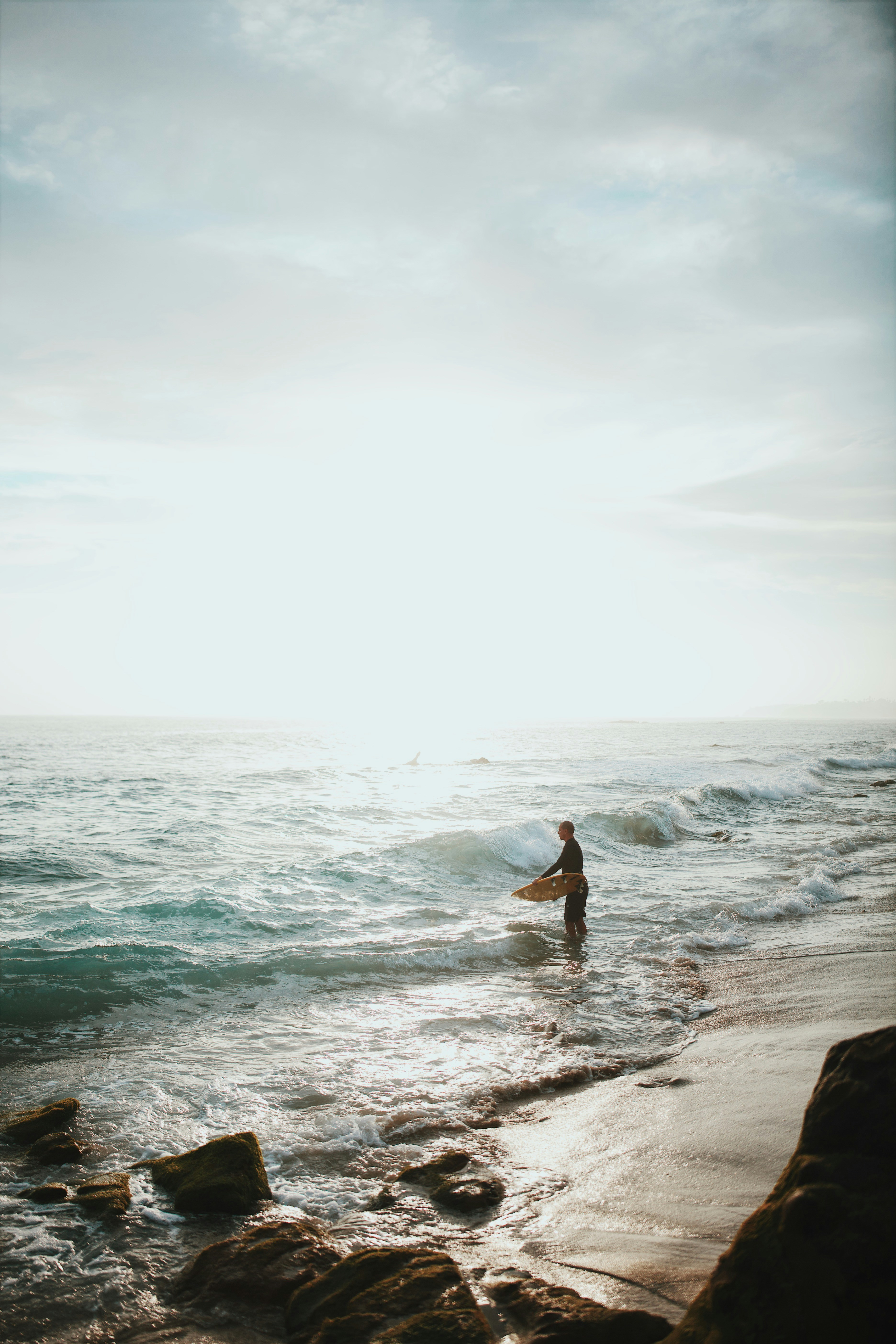 Surfer Entering Ocean at Beach