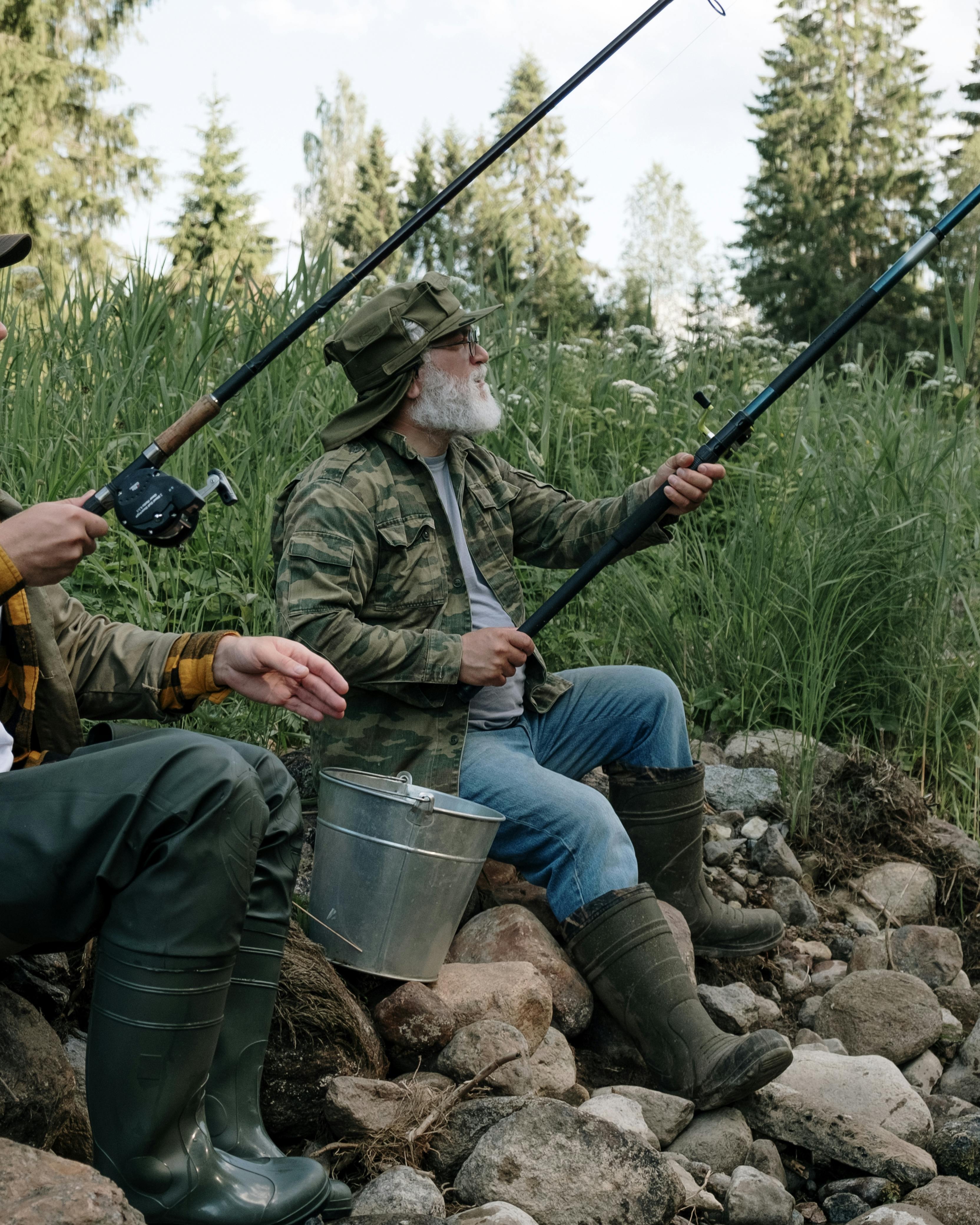 Two Men Fishing by Rocky Riverbank