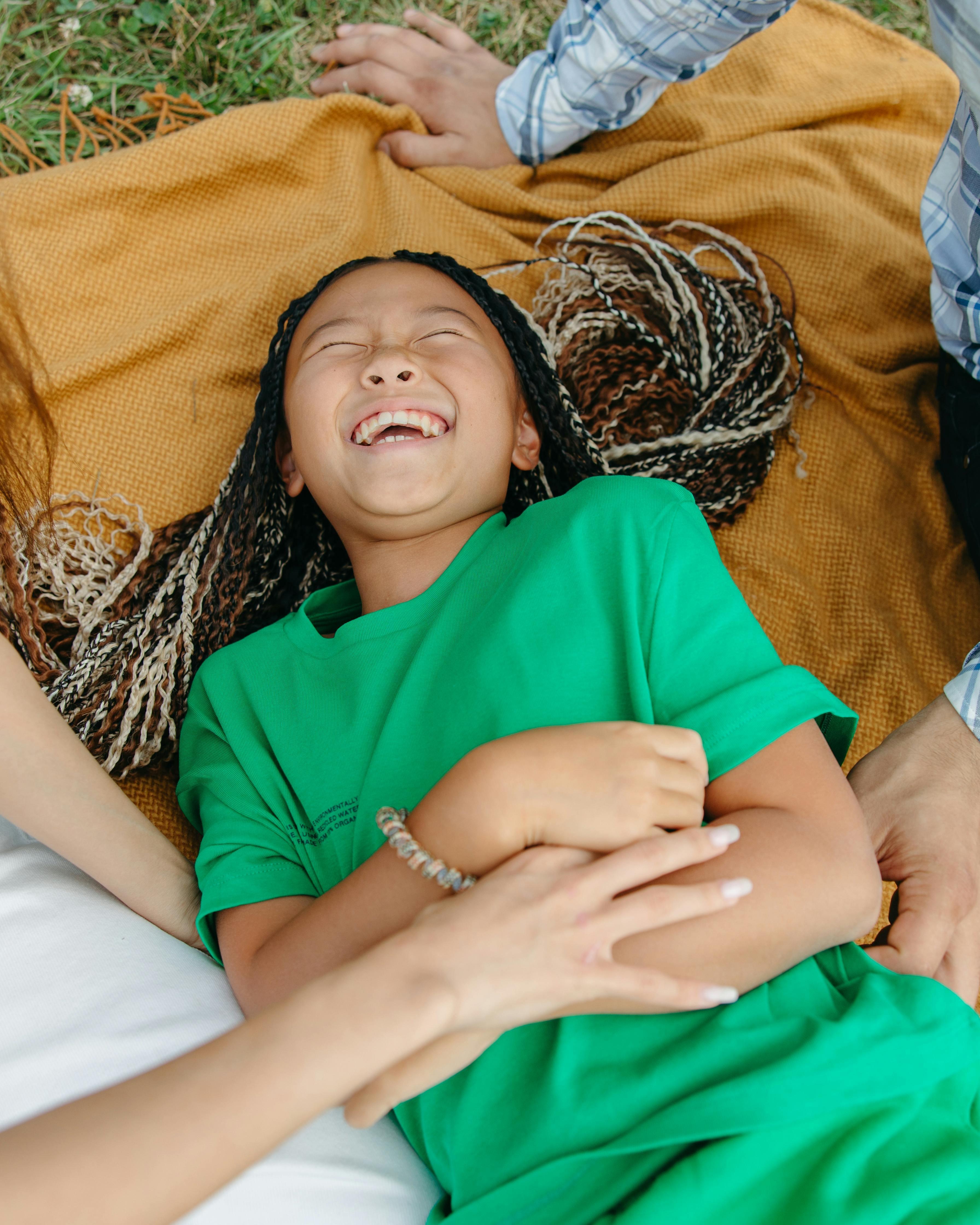 Laughing Girl Lying on Picnic Blanket