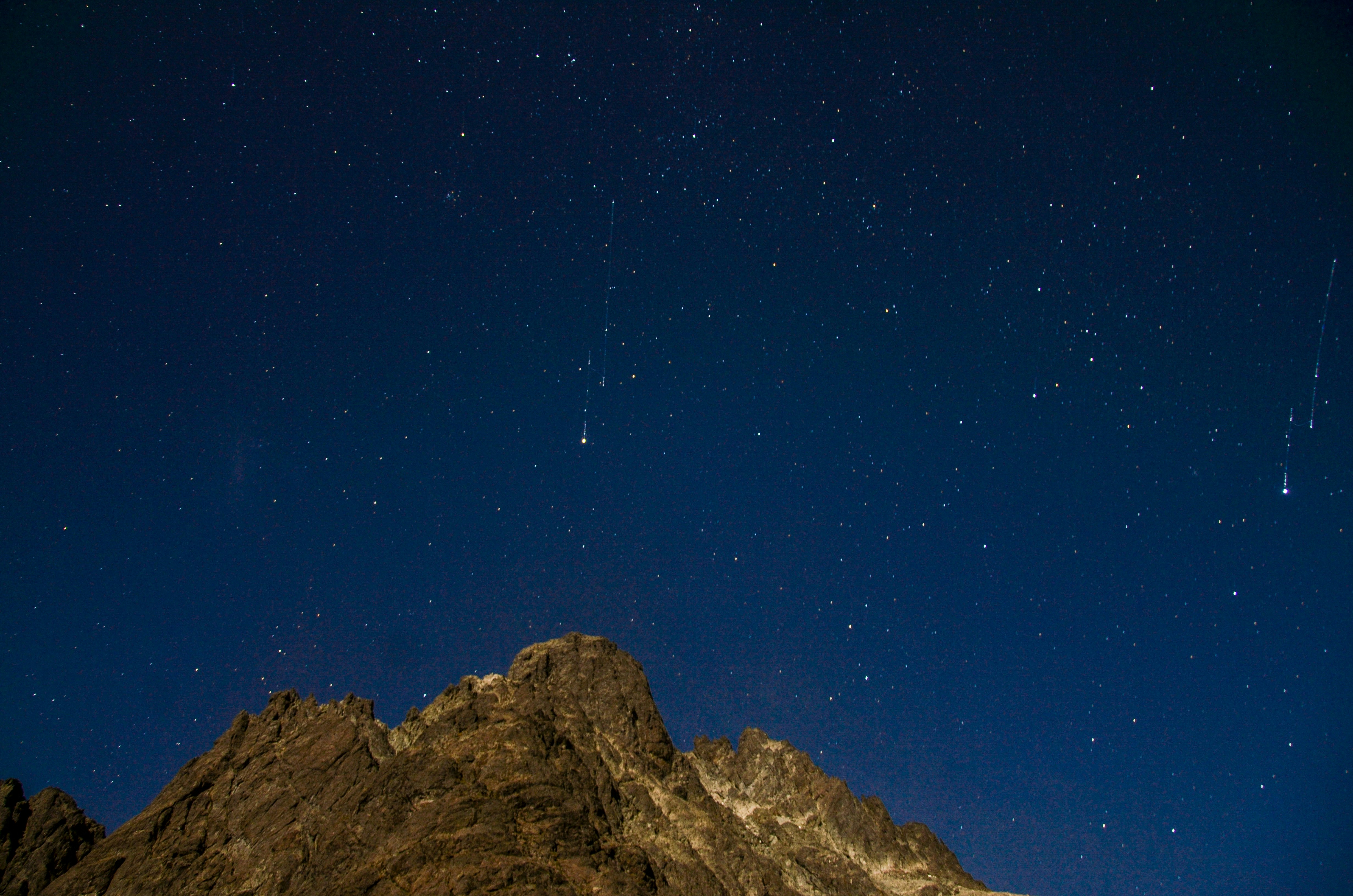 Night Sky With Meteors Over Mountain Peak