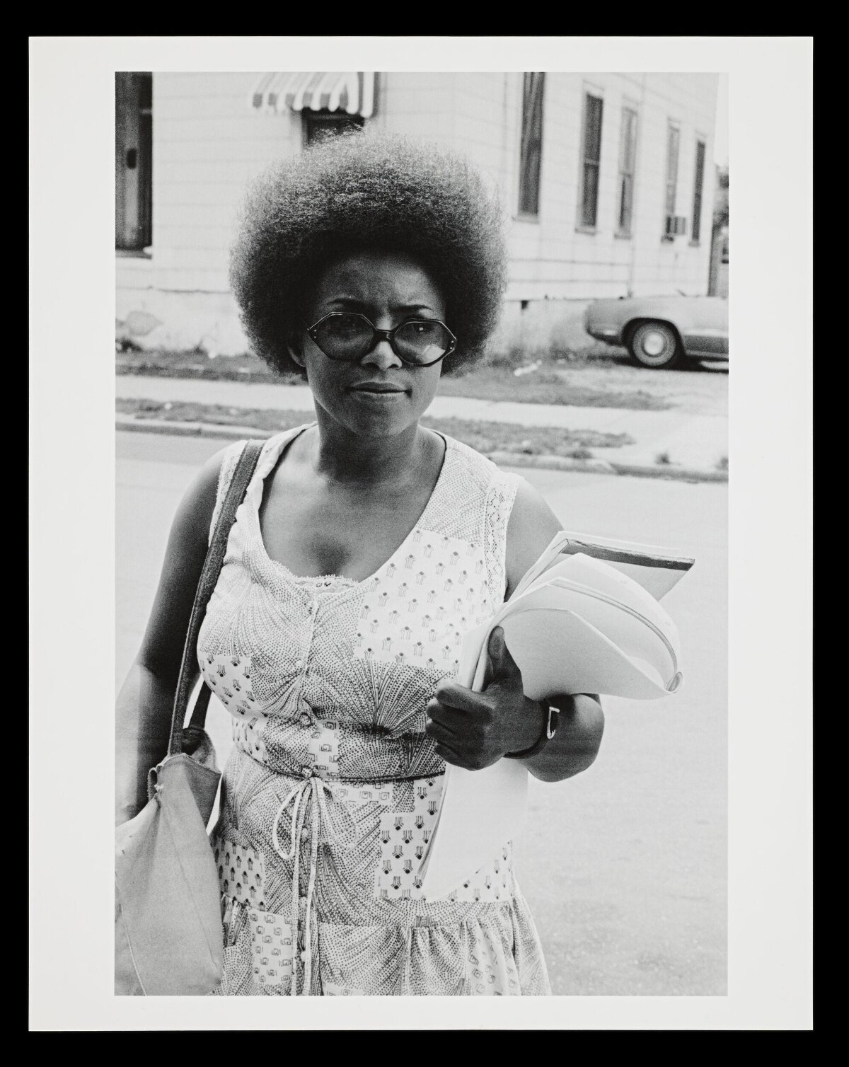 Black Woman Holding Papers On Urban Street