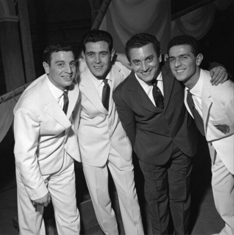 Four Men In Suits Posing Together