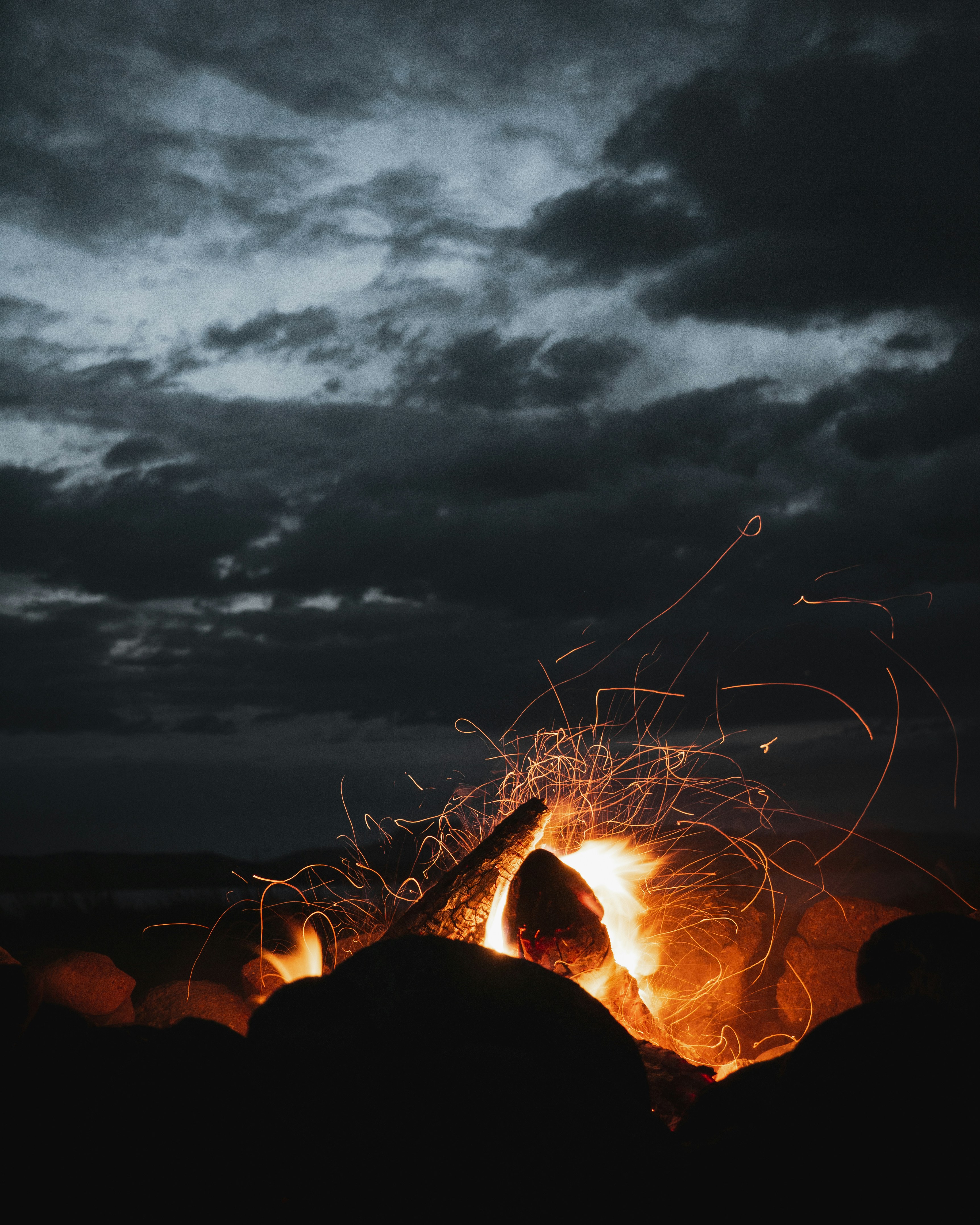 Night Campfire Under Cloudy Sky