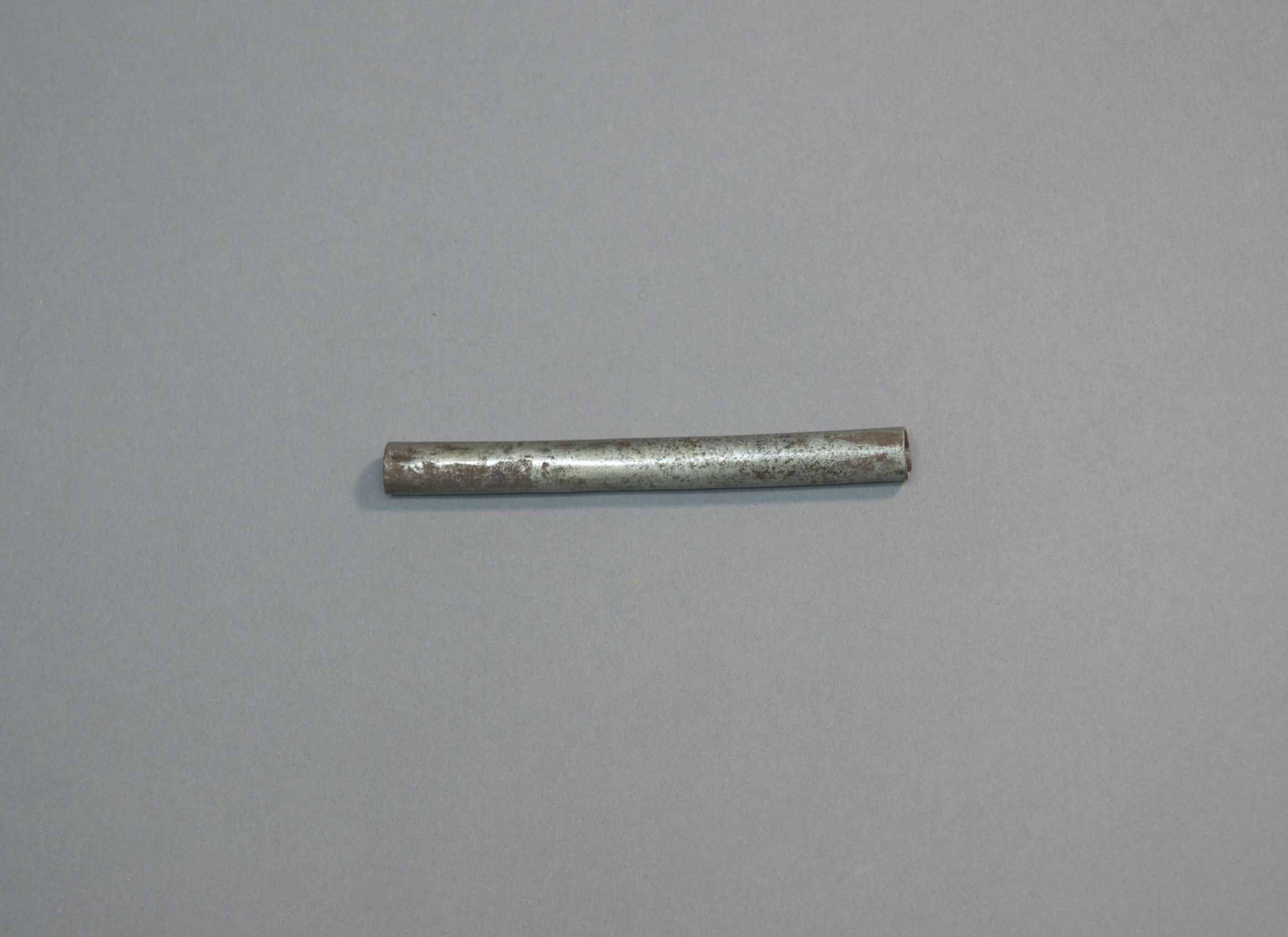 Worn Metal Tube on Gray Background