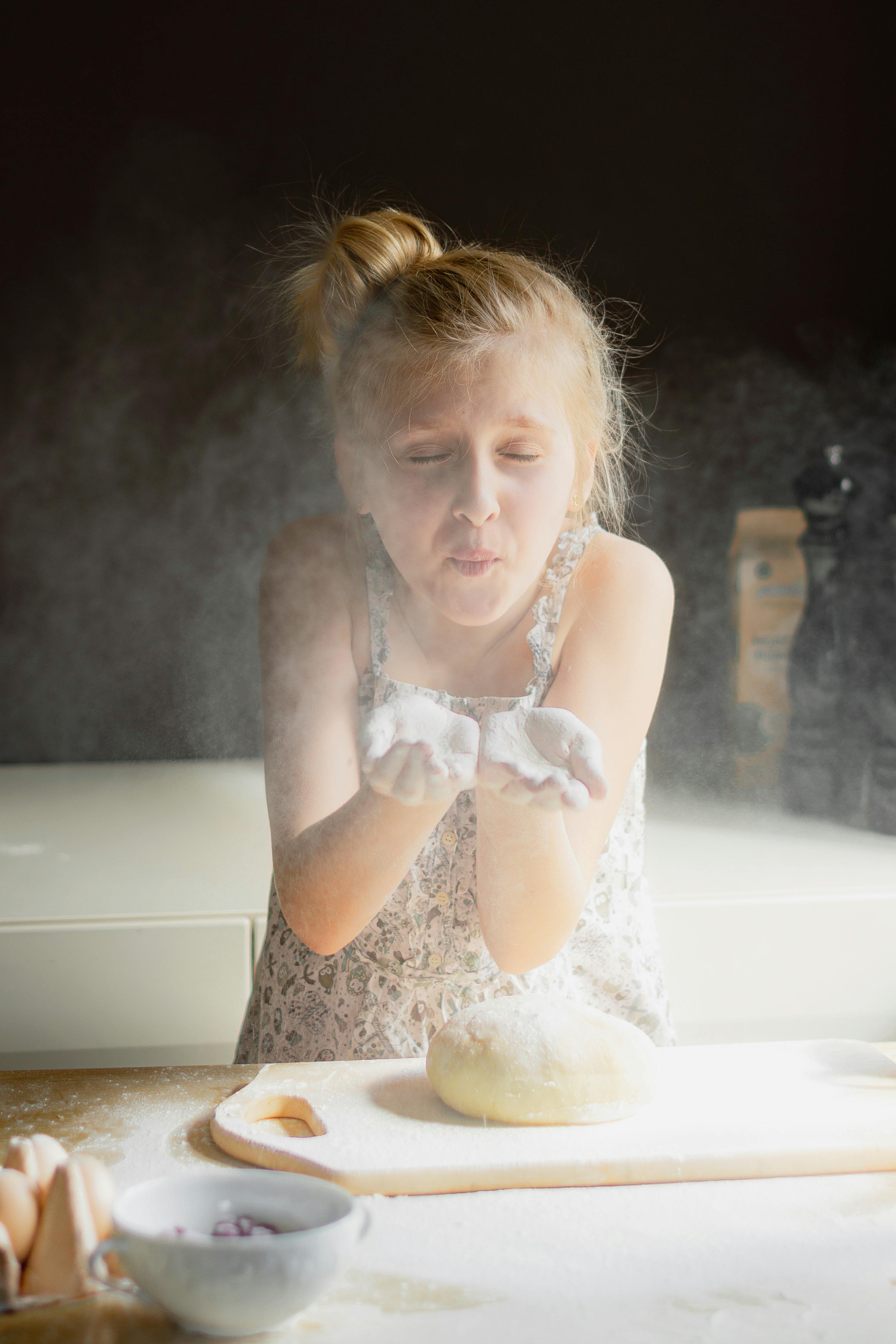 Girl Blowing Flour While Baking