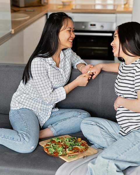 Two Women Sharing Pizza at Home