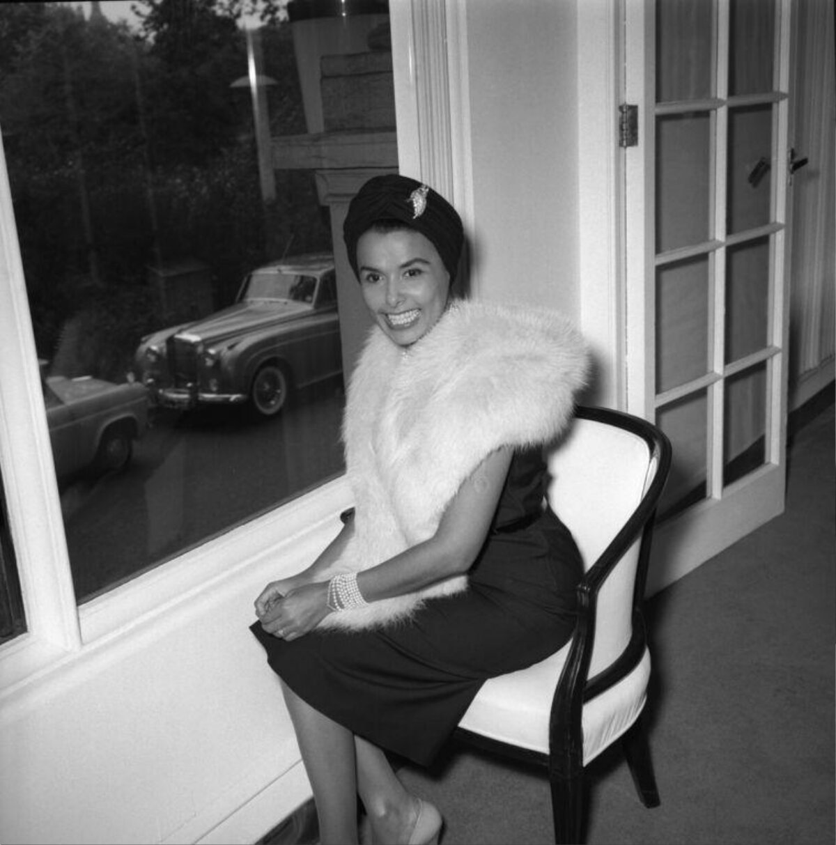 Smiling Woman in Formal Attire by Window