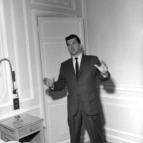 Man In Suit Gesturing In Room