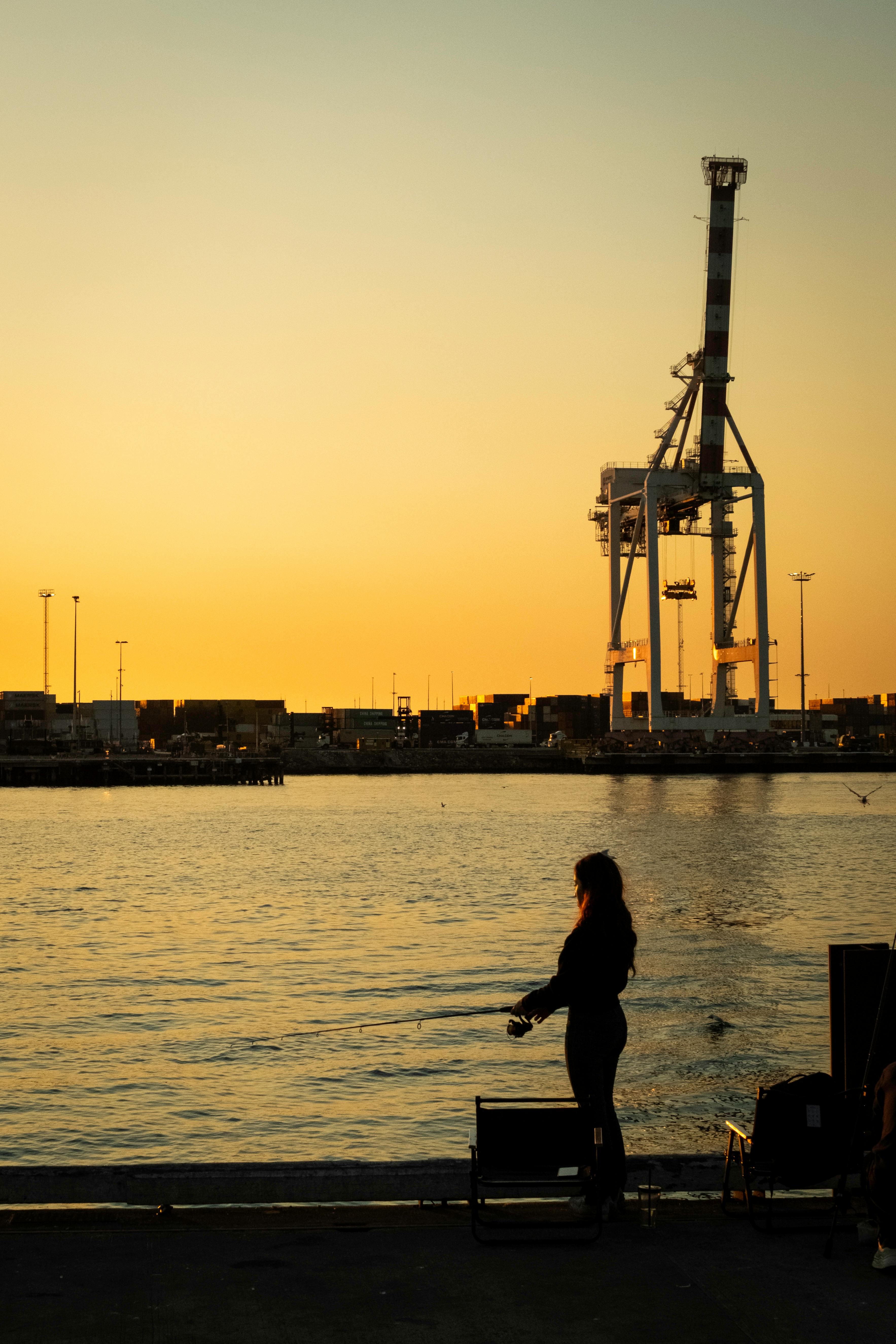 Woman Fishing at Port Sunset