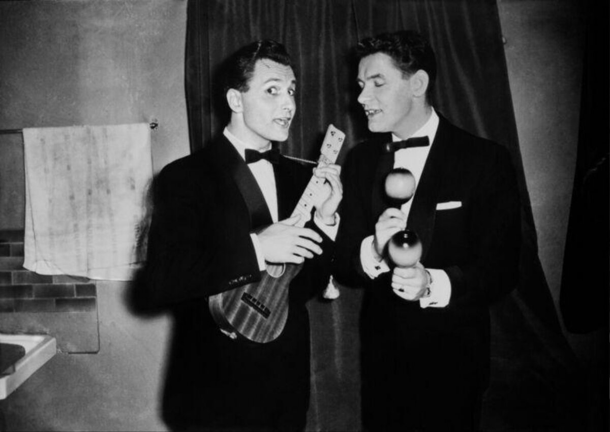 Two Men In Tuxedos Holding Instruments